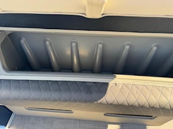 Interior of 2025 Sun Tracker Fishin' Barge 22 DLX with storage compartment.