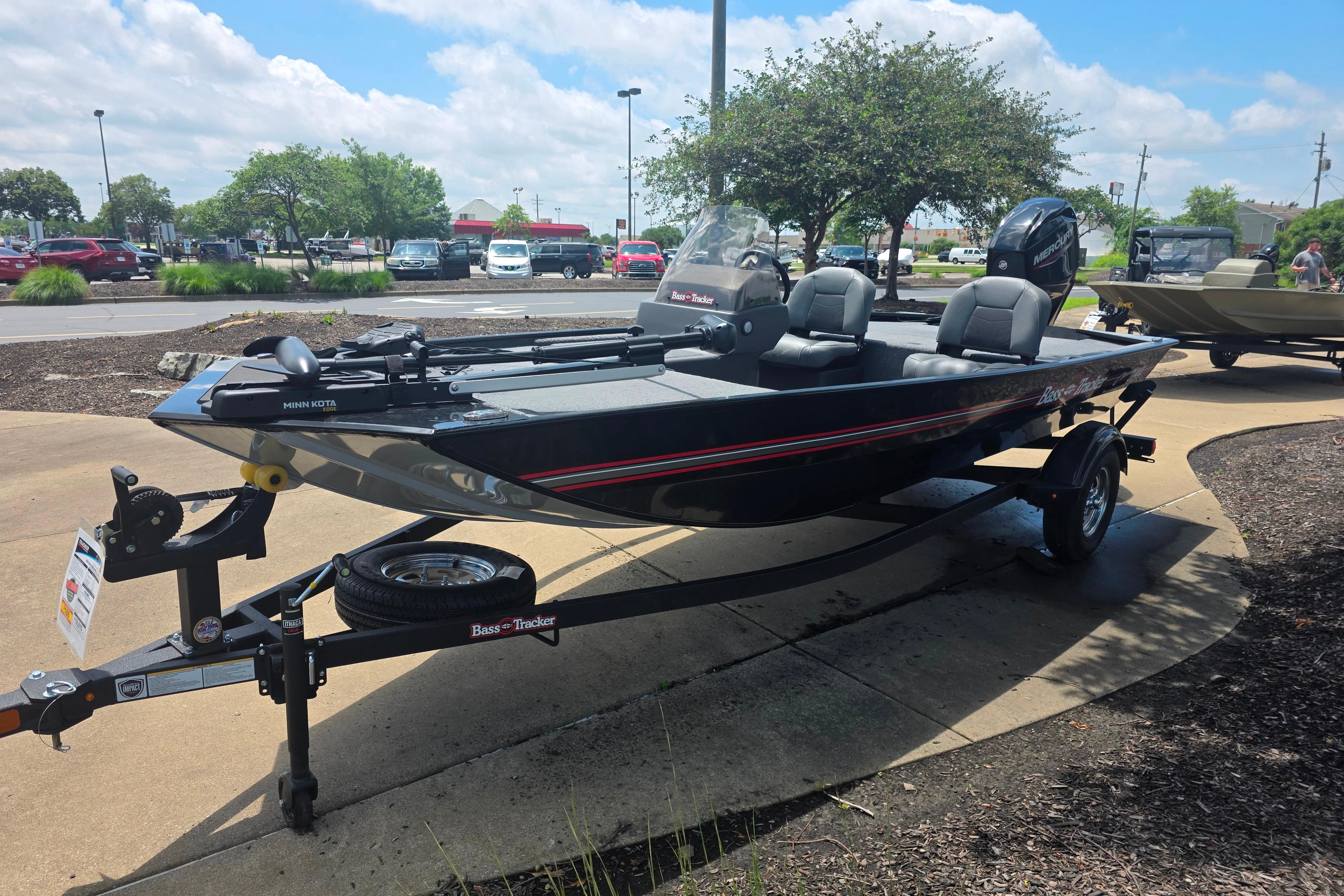 2026 Tracker Bass Tracker Classic XL boat on display in a parking lot under a sunny sky.