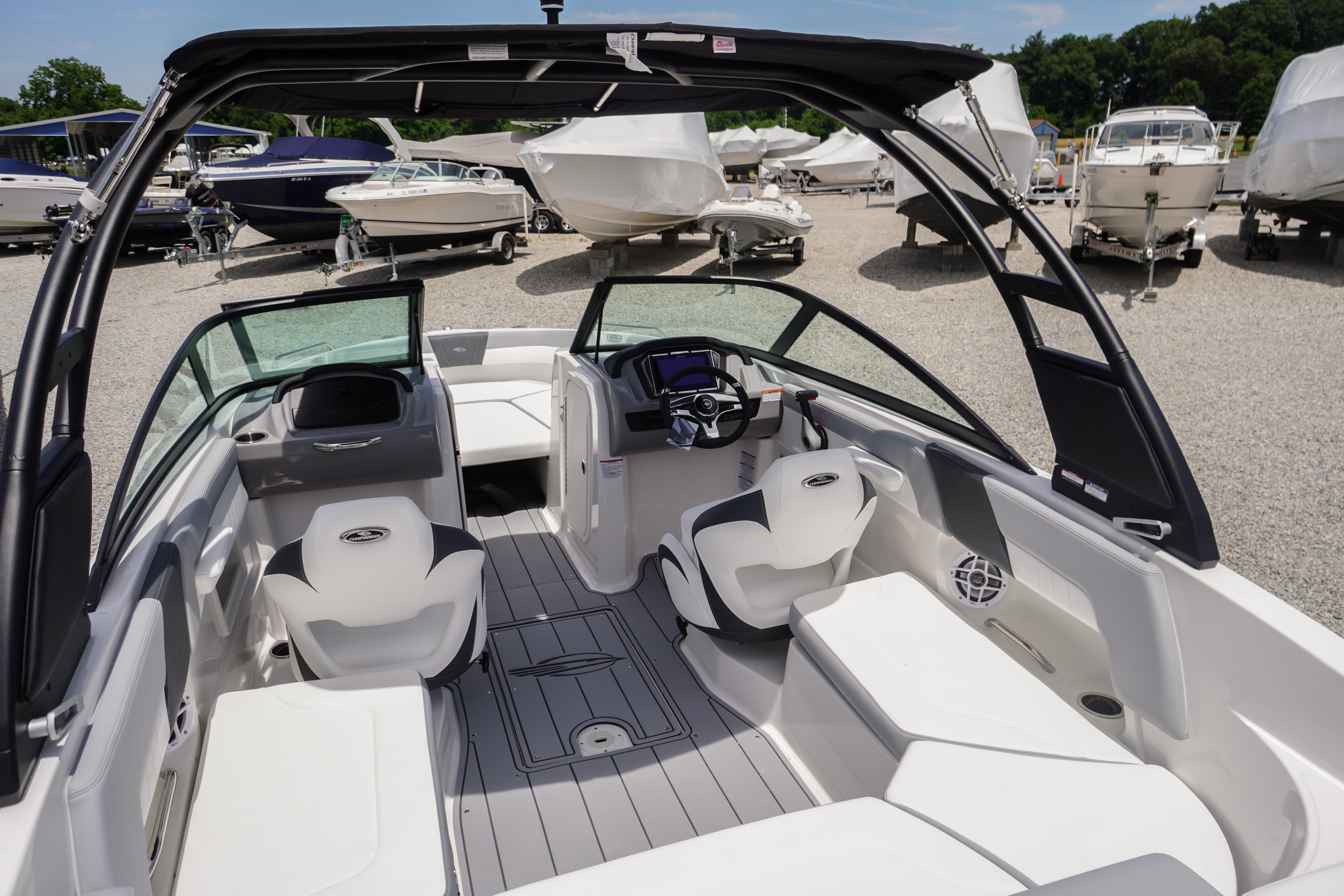 2026 Chaparral 23 SSi OB boat interior with modern seating and dashboard, parked outdoors.