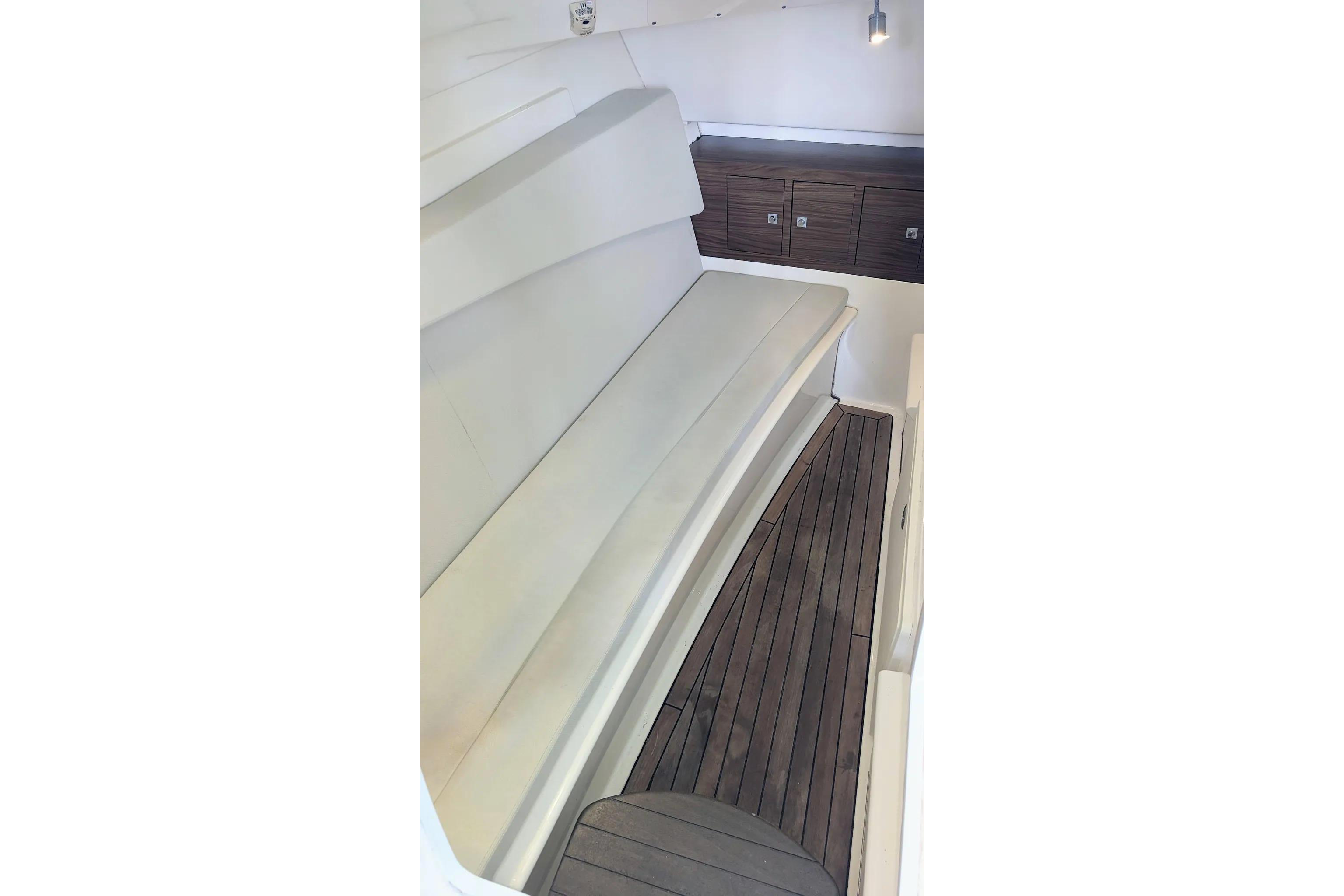 Interior view of 2017 Boston Whaler 320 Vantage with cushioned seating and wooden flooring.