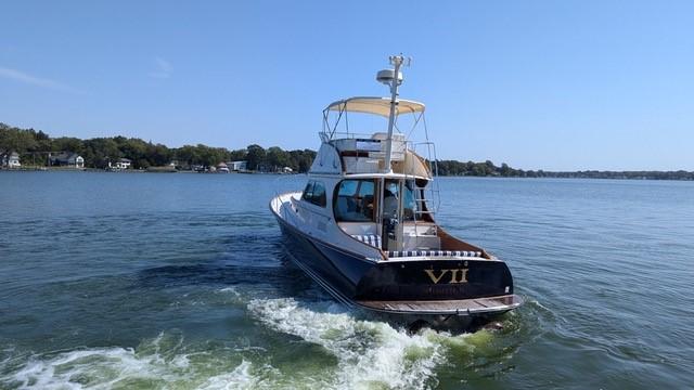 2007 Hinckley Talaria 44 Flybridge yacht cruising on a calm lake.