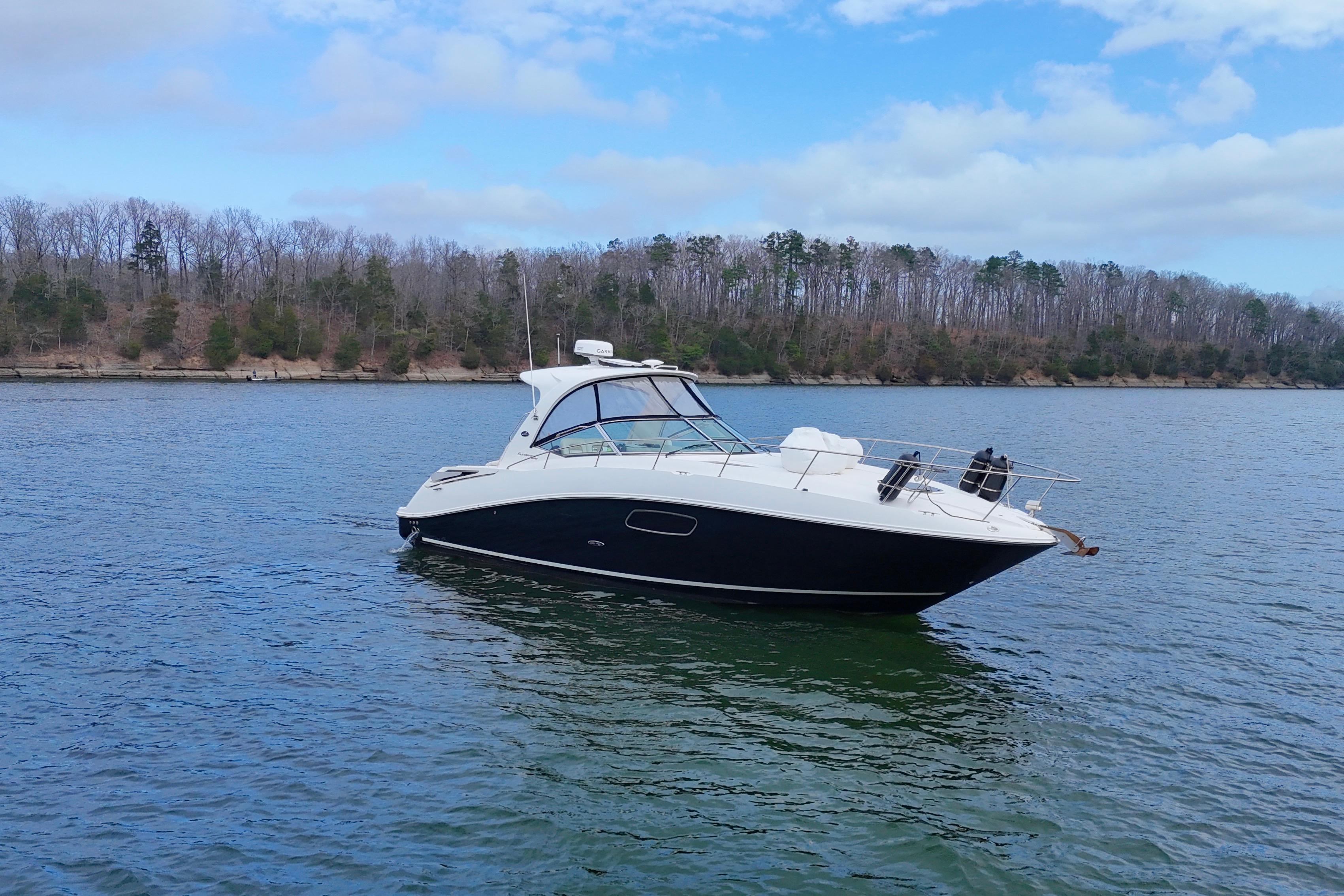 2009 Sea Ray Sundancer 350 yacht on a serene lake with forested shoreline.