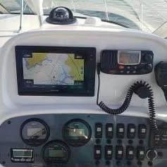 The image shows a boat dashboard with a navigation system and various instruments.