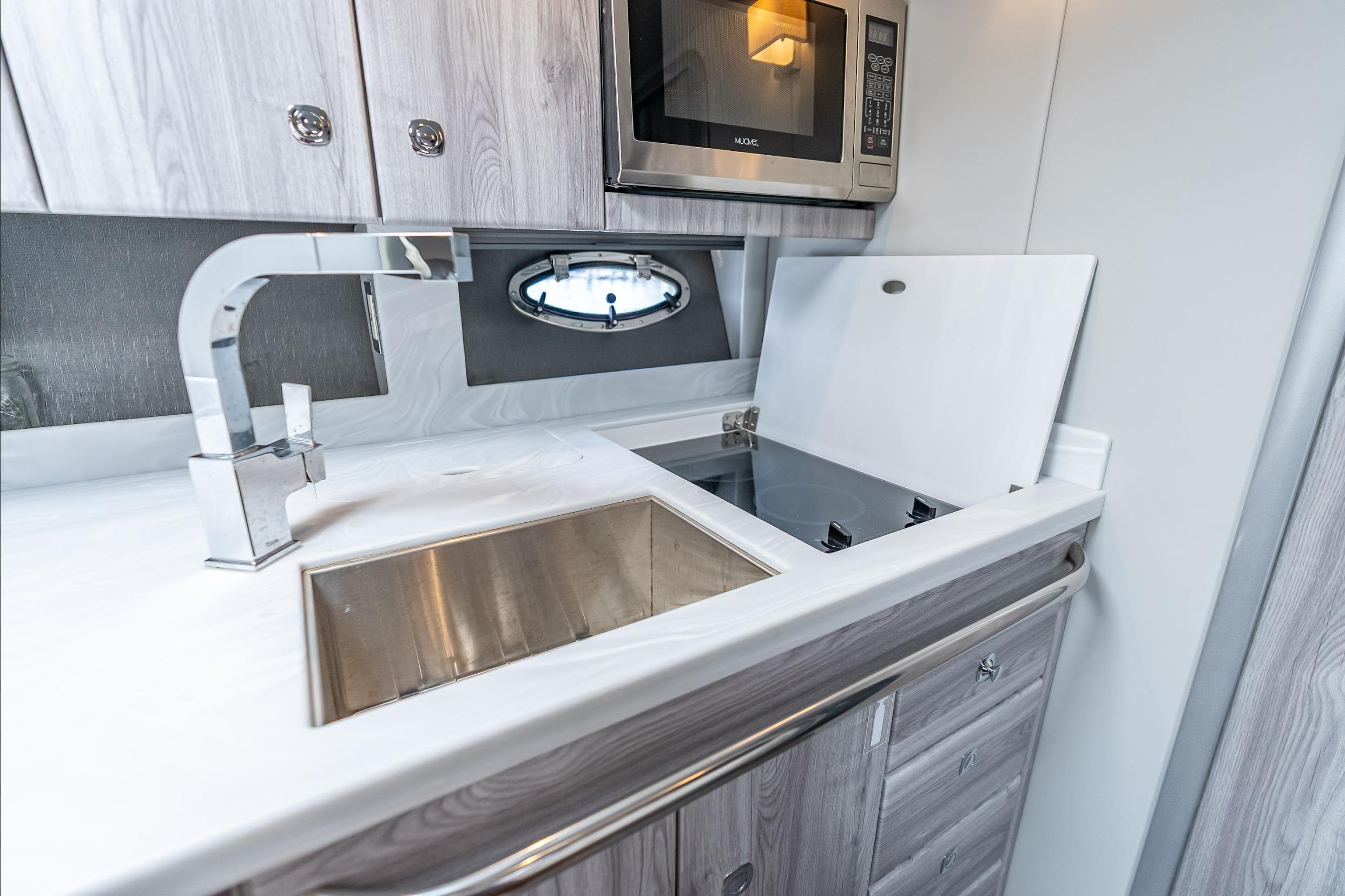 Modern kitchen in 2022 Formula 40 Performance Cruiser with sink, stove, and microwave.