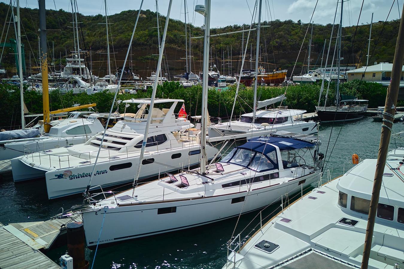 2014 Beneteau Oceanis 48 sailboat docked in a marina with other vessels.