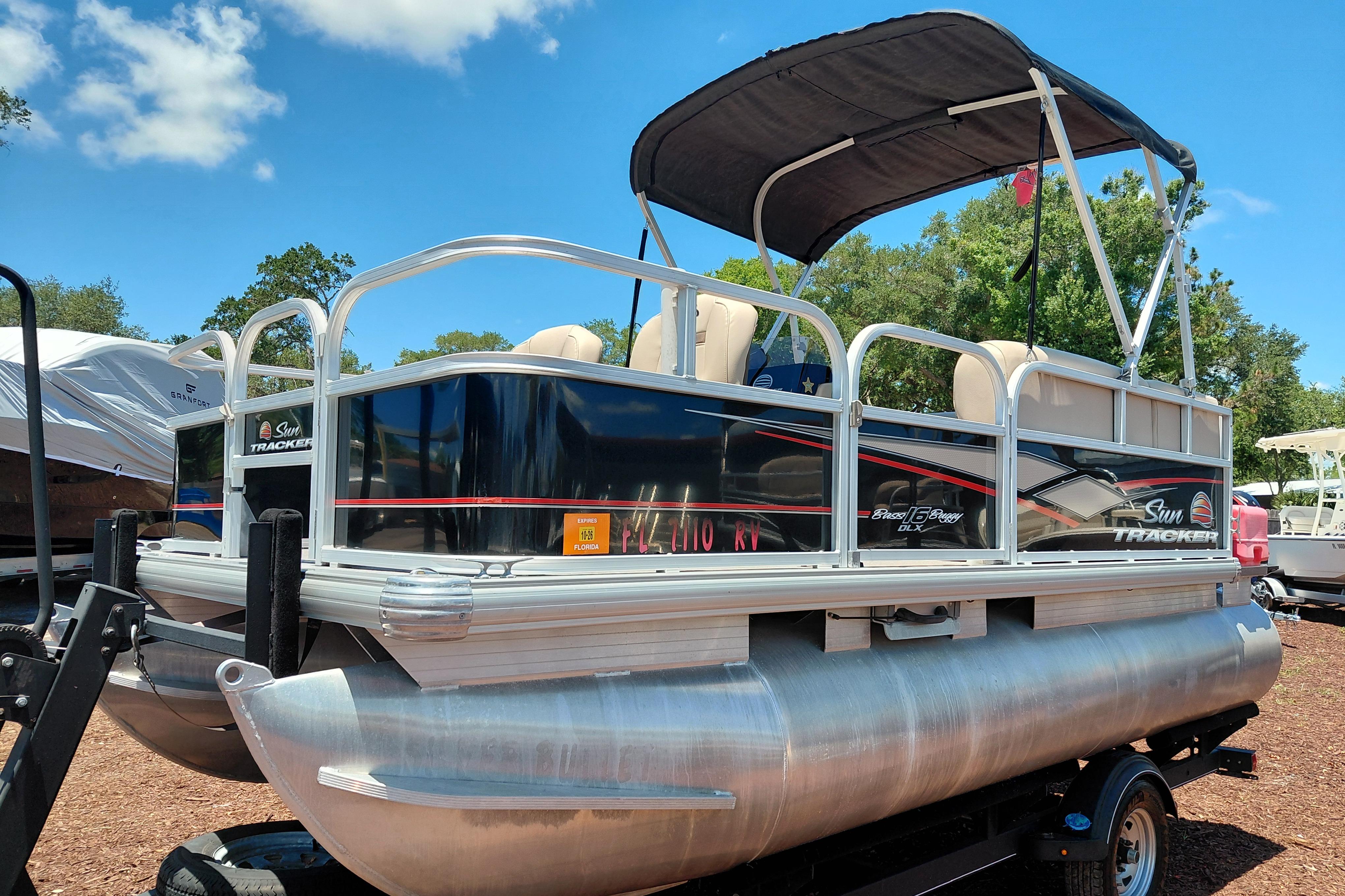 2019 Sun Tracker Bass Buggy 16 DLX pontoon boat on trailer under blue sky.