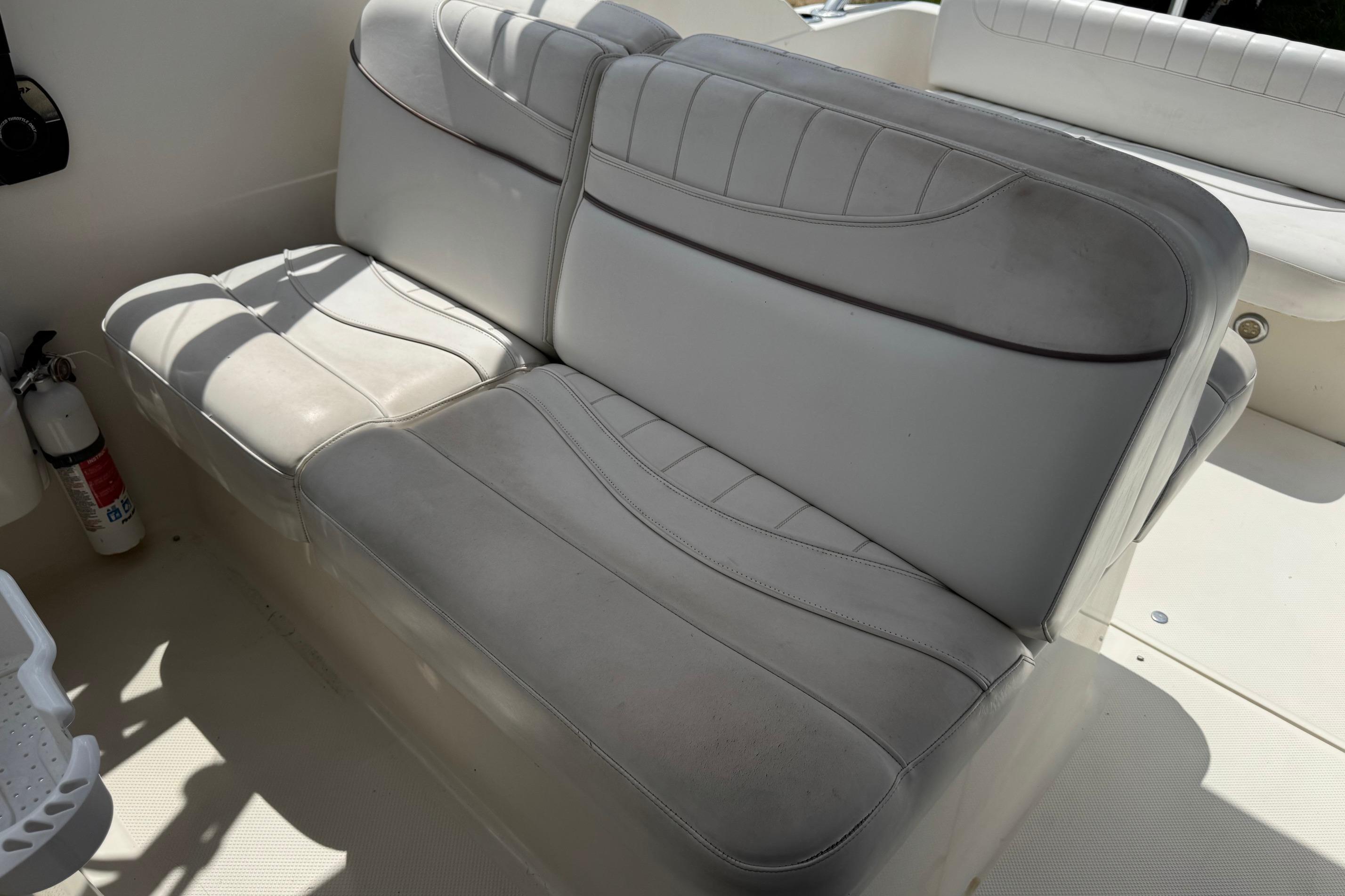 Gray seating on a 2000 Maxum 2400 SCR boat, with visible fire extinguisher nearby.