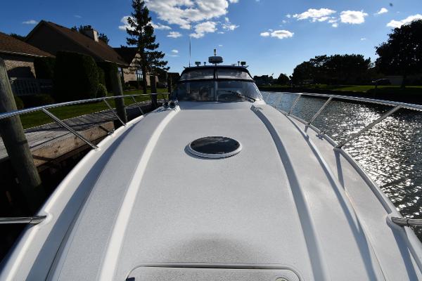 1997 Sunseeker Camargue 47 yacht on a sunny day, docked by a canal.
