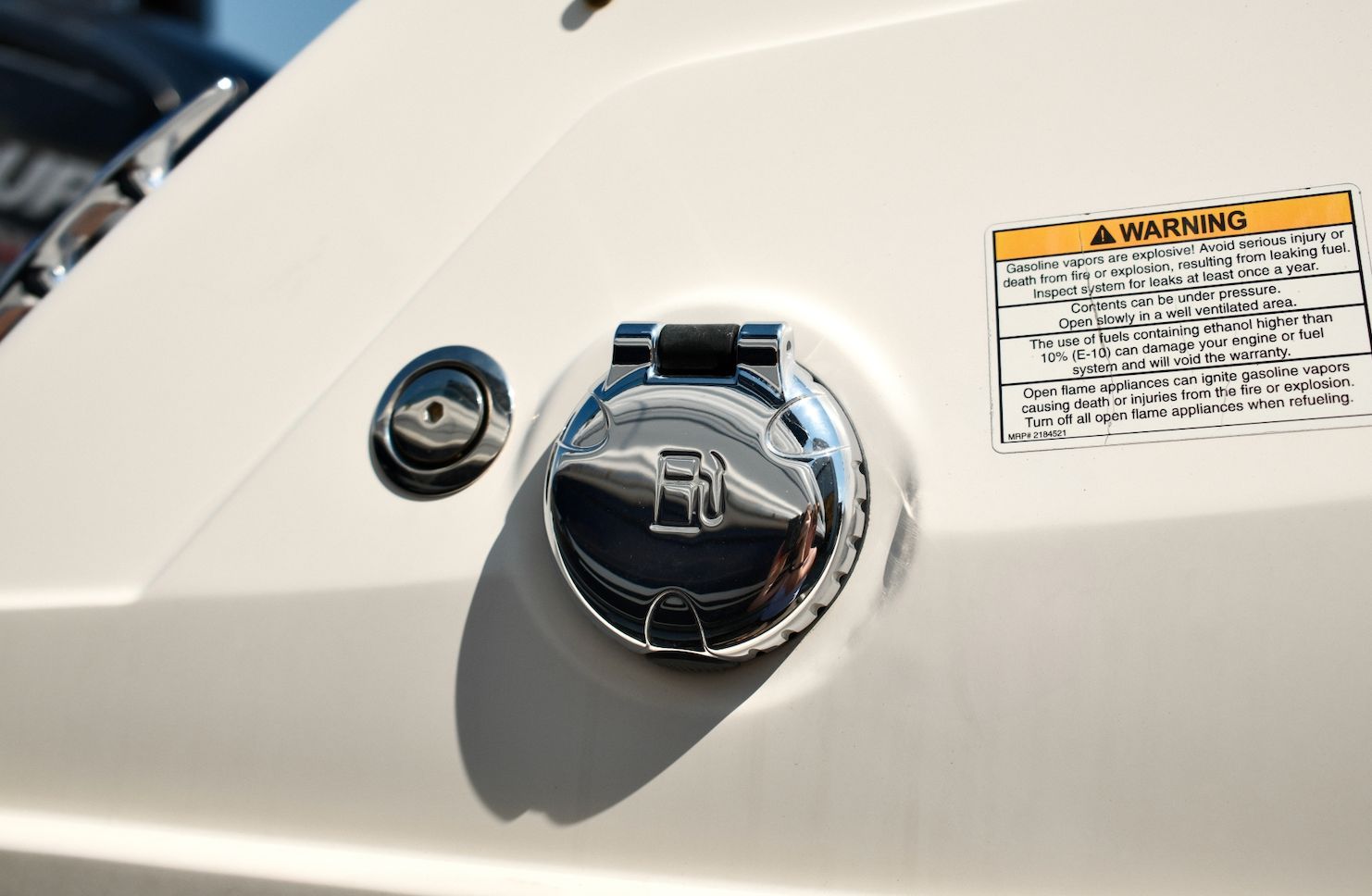 Close-up of a fuel cap with a warning label on a 2019 Bayliner VR4 Bowrider OB.