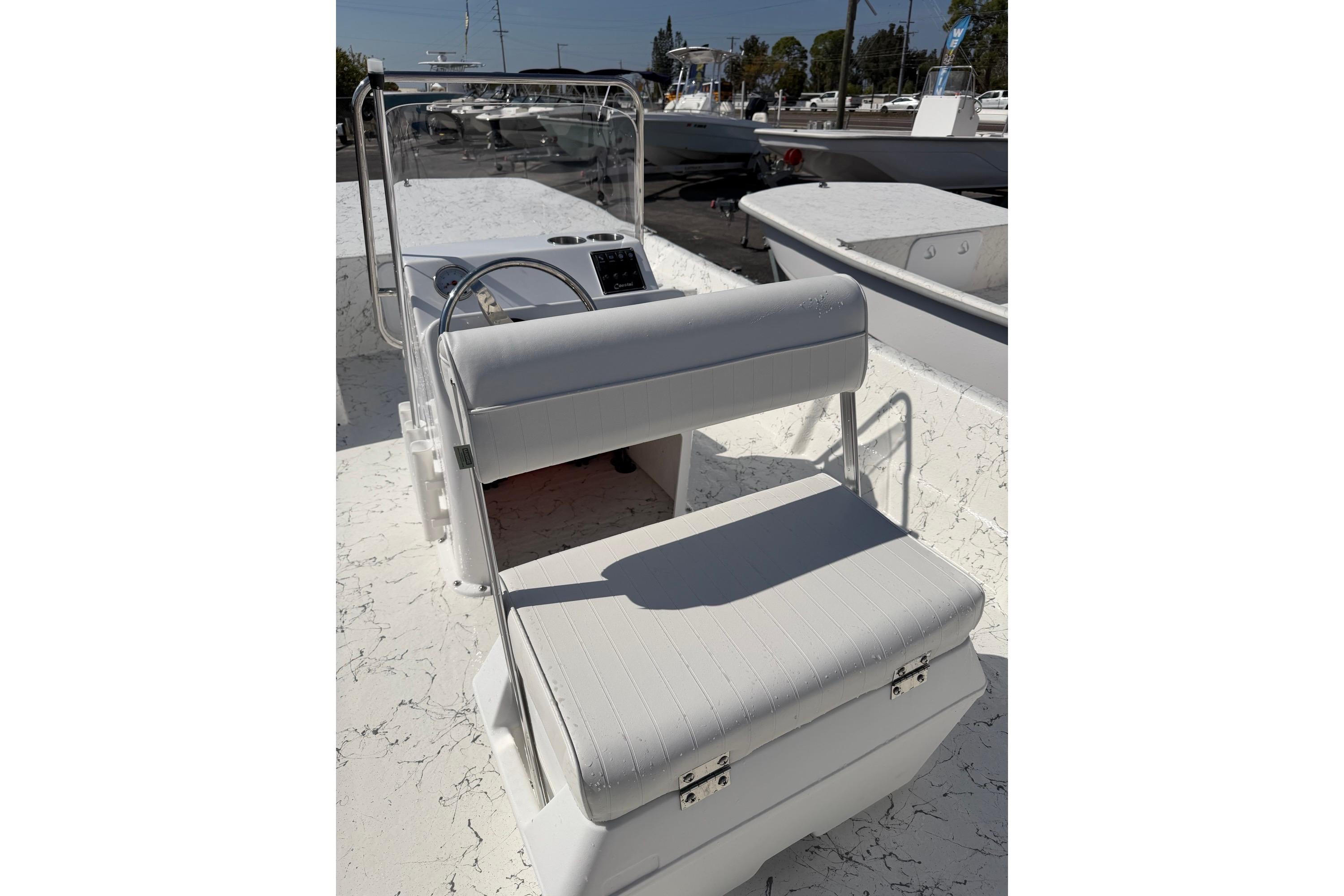 2027 Coastal Skiff 184 boat interior with steering console and cushioned seating.