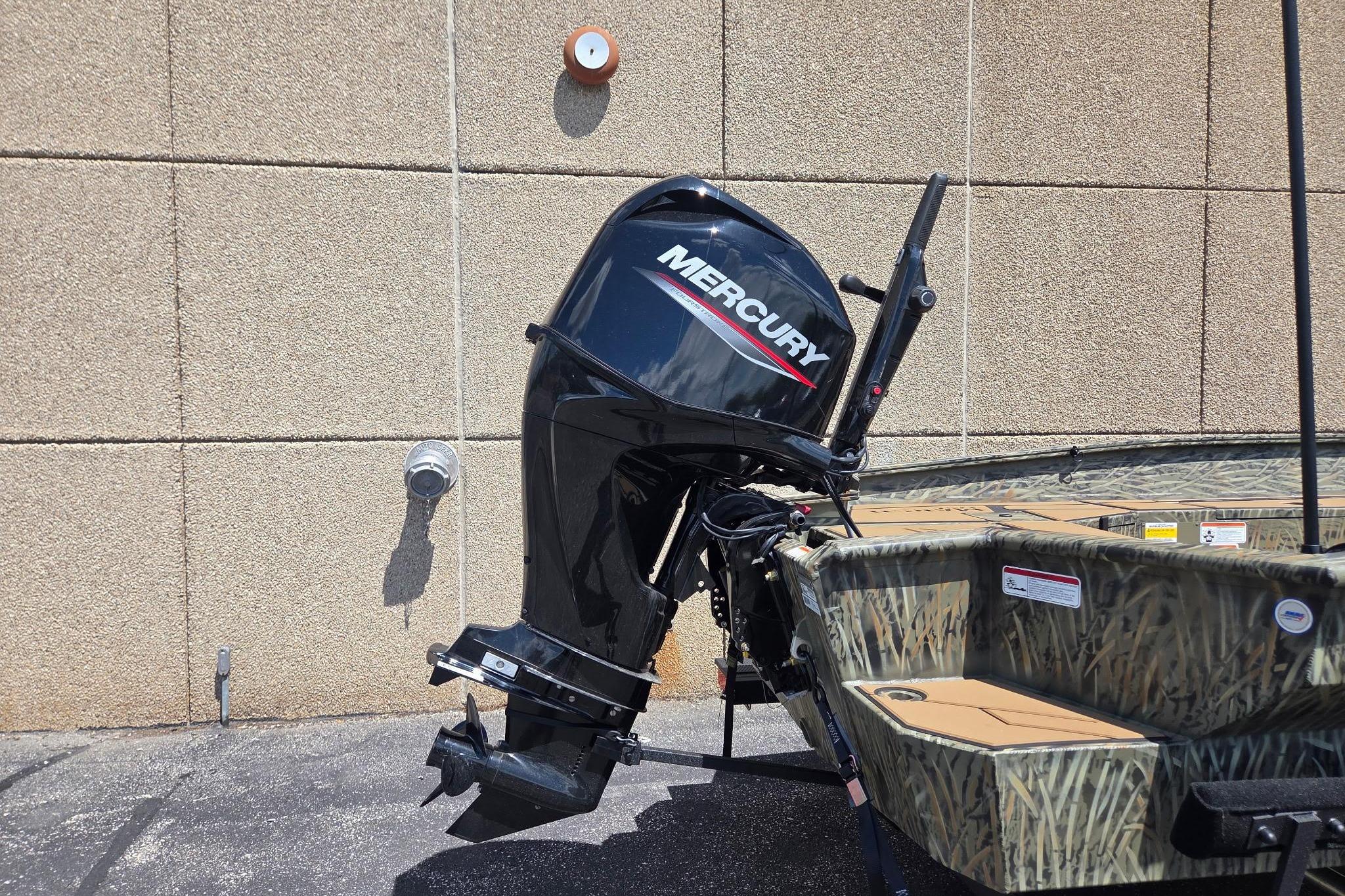 2026 Tracker Grizzly 1756 T Marsh boat with Mercury outboard motor, parked outdoors.