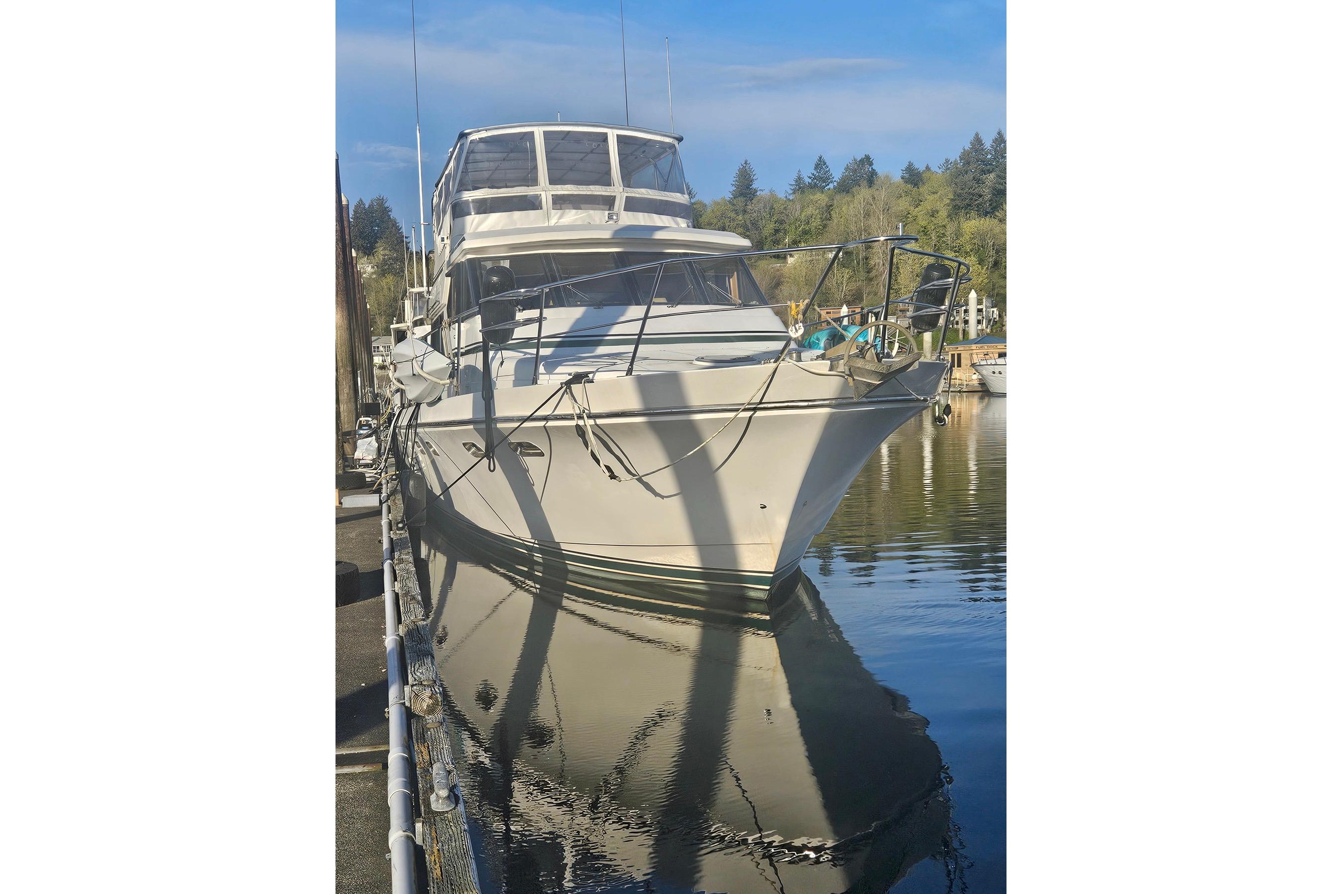 Luxury 1995 Symbol 55 yacht docked in serene marina setting.