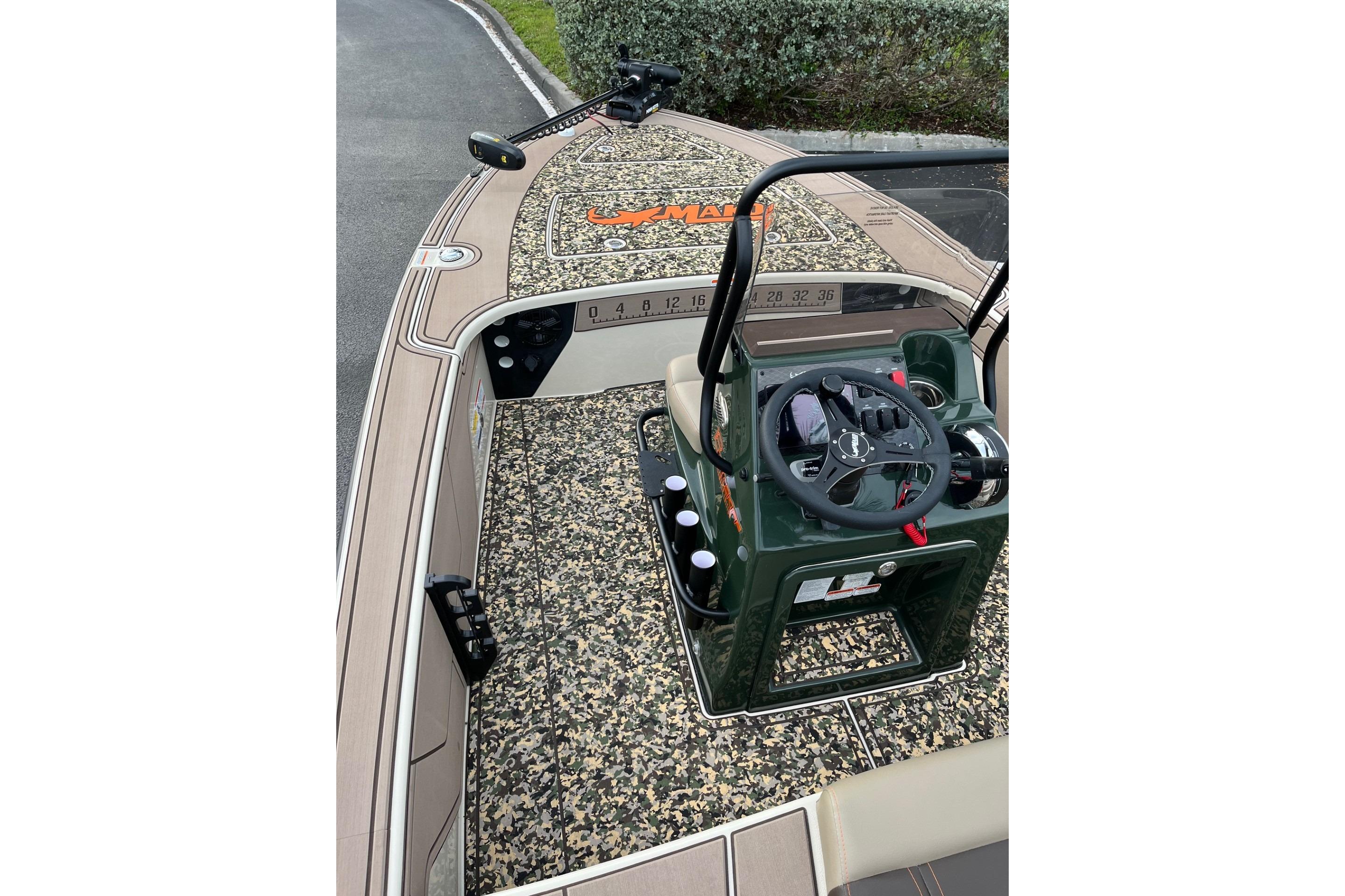 2026 Mako 18 Pro Skiff Backwater Edition boat interior with camouflage design and steering console.