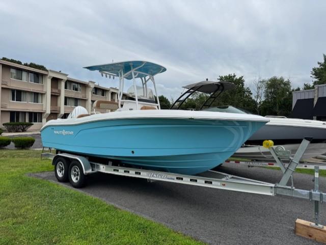 2025 NauticStar 222L Offshore boat on trailer, parked outdoors near buildings.