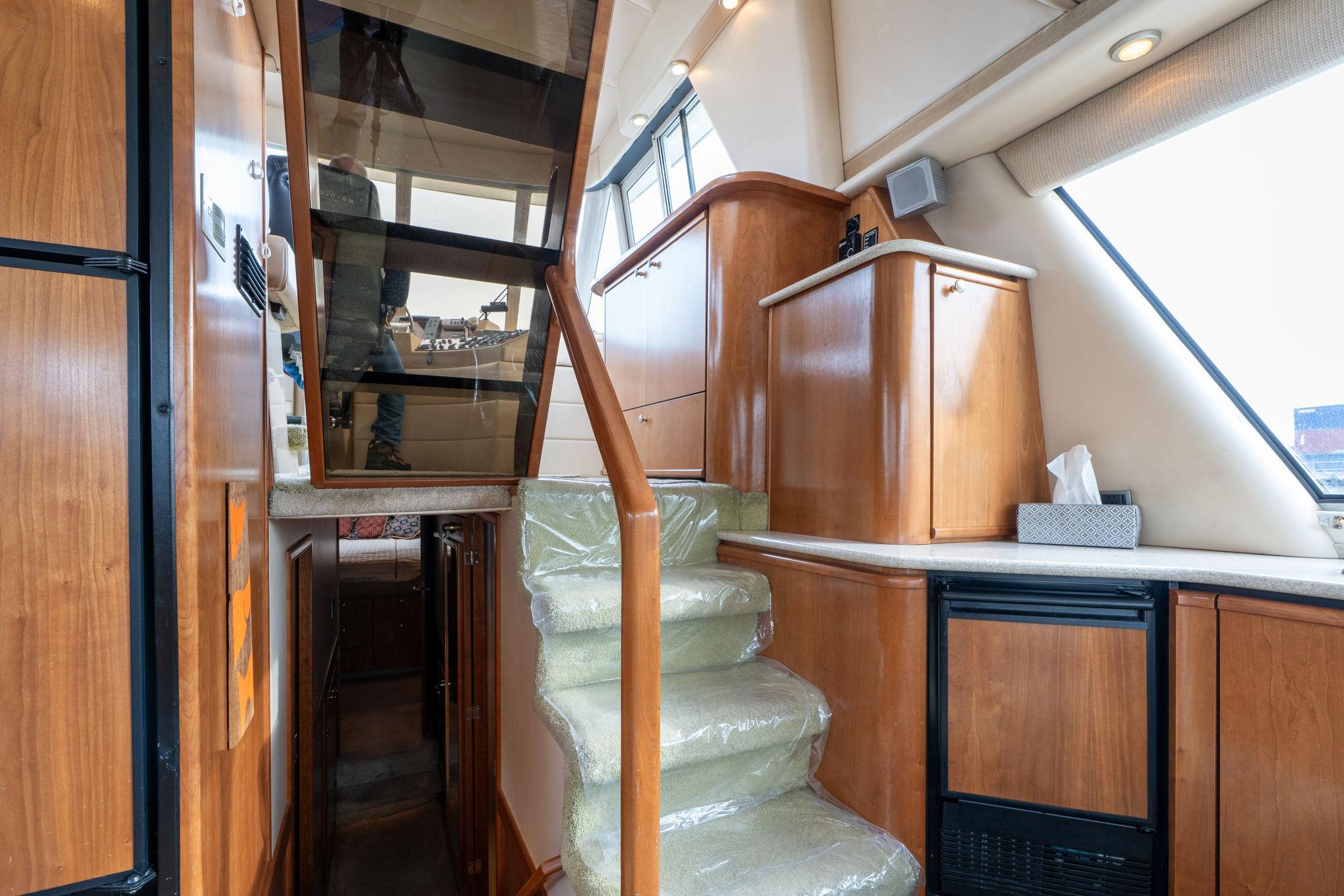 Interior of 2003 Meridian 490 Pilothouse with wooden cabinetry and carpeted stairs.