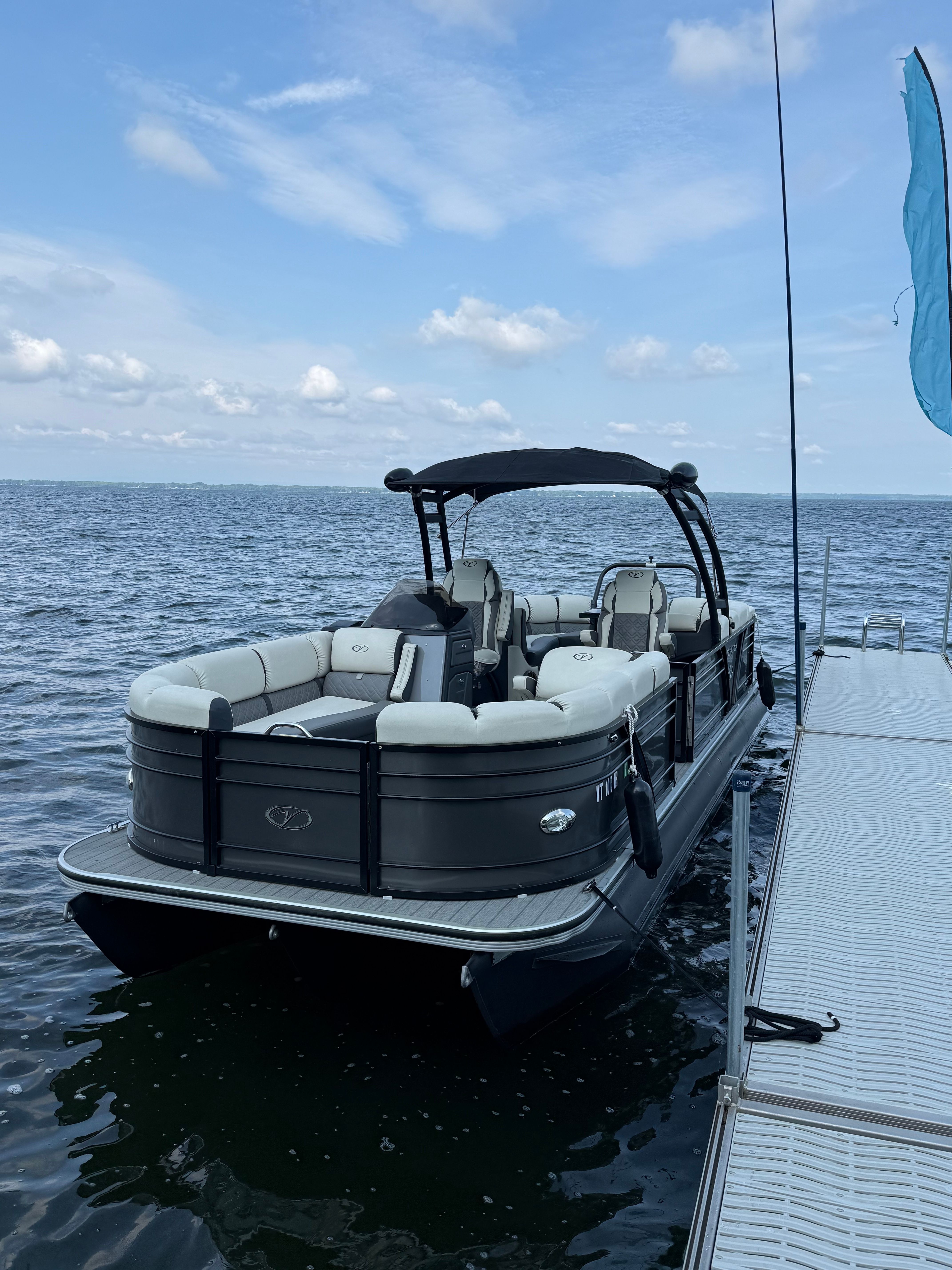 A 2024 Veranda VP 25RCT pontoon boat docked at a pier on calm water.
