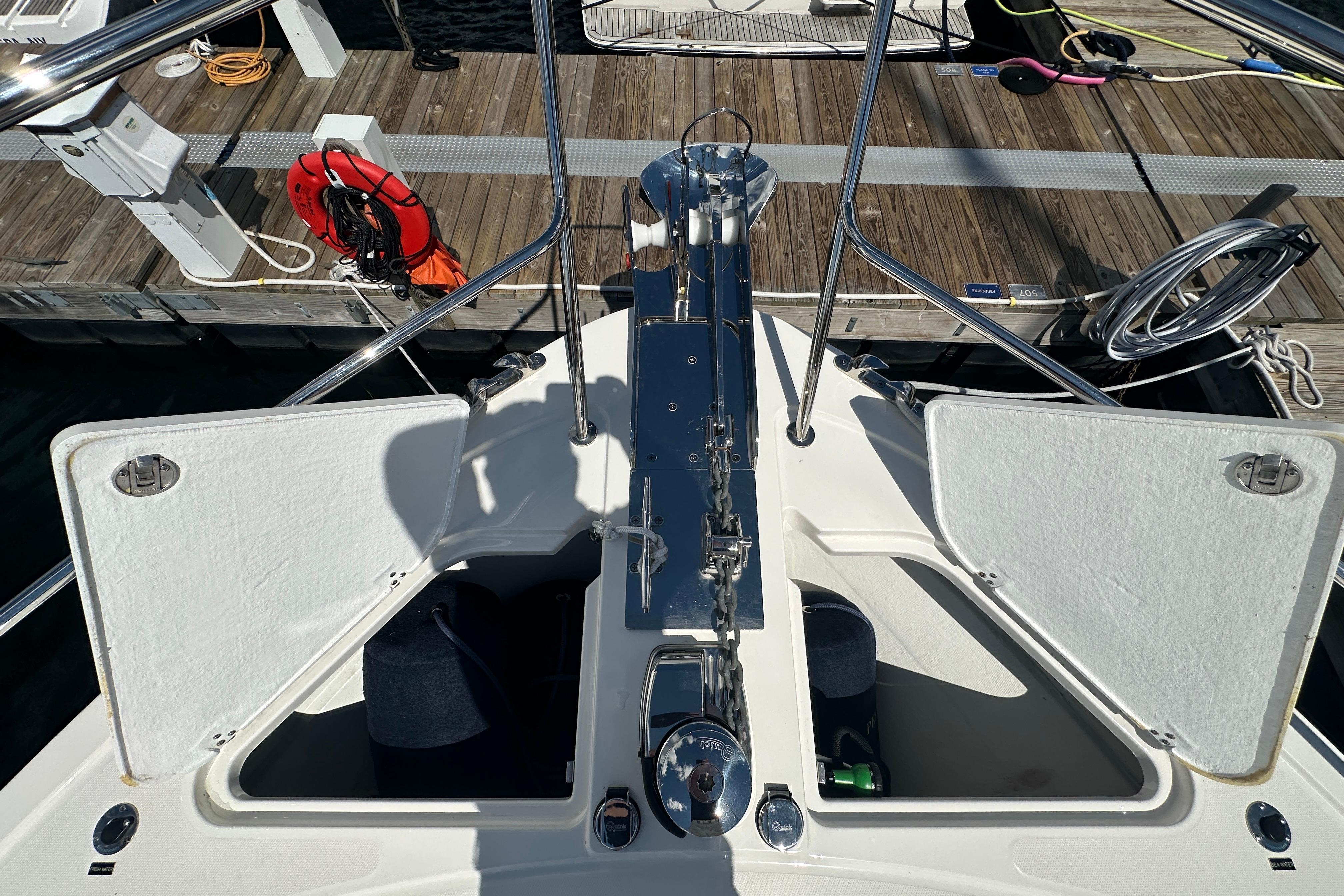 Bow view of 2025 Sabre 48 Salon Express yacht docked, showcasing open storage compartments.