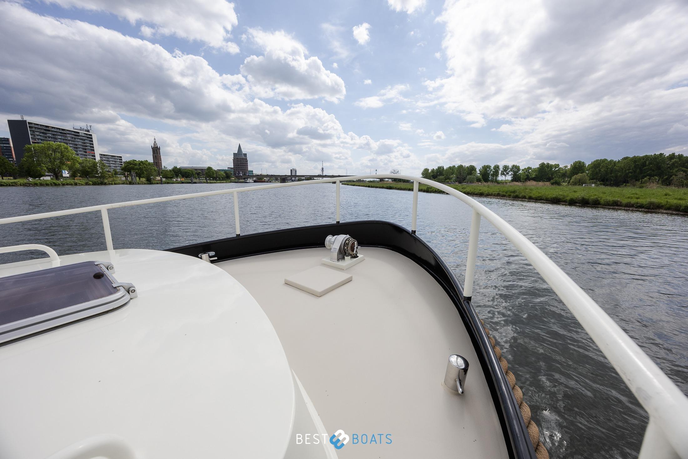 Bow view of 2004 Vripack 965 OK yacht cruising on a scenic river.