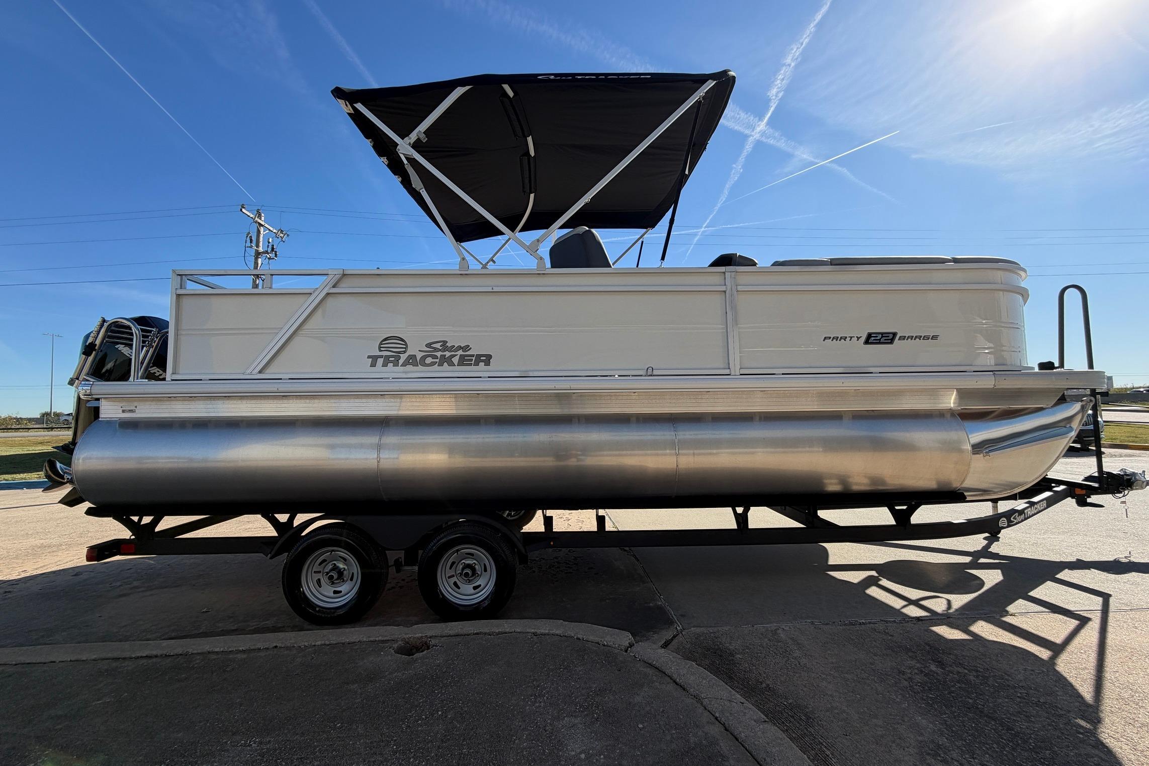 2026 Sun Tracker Party Barge 22 RF XP3 pontoon boat on trailer, under clear blue sky.