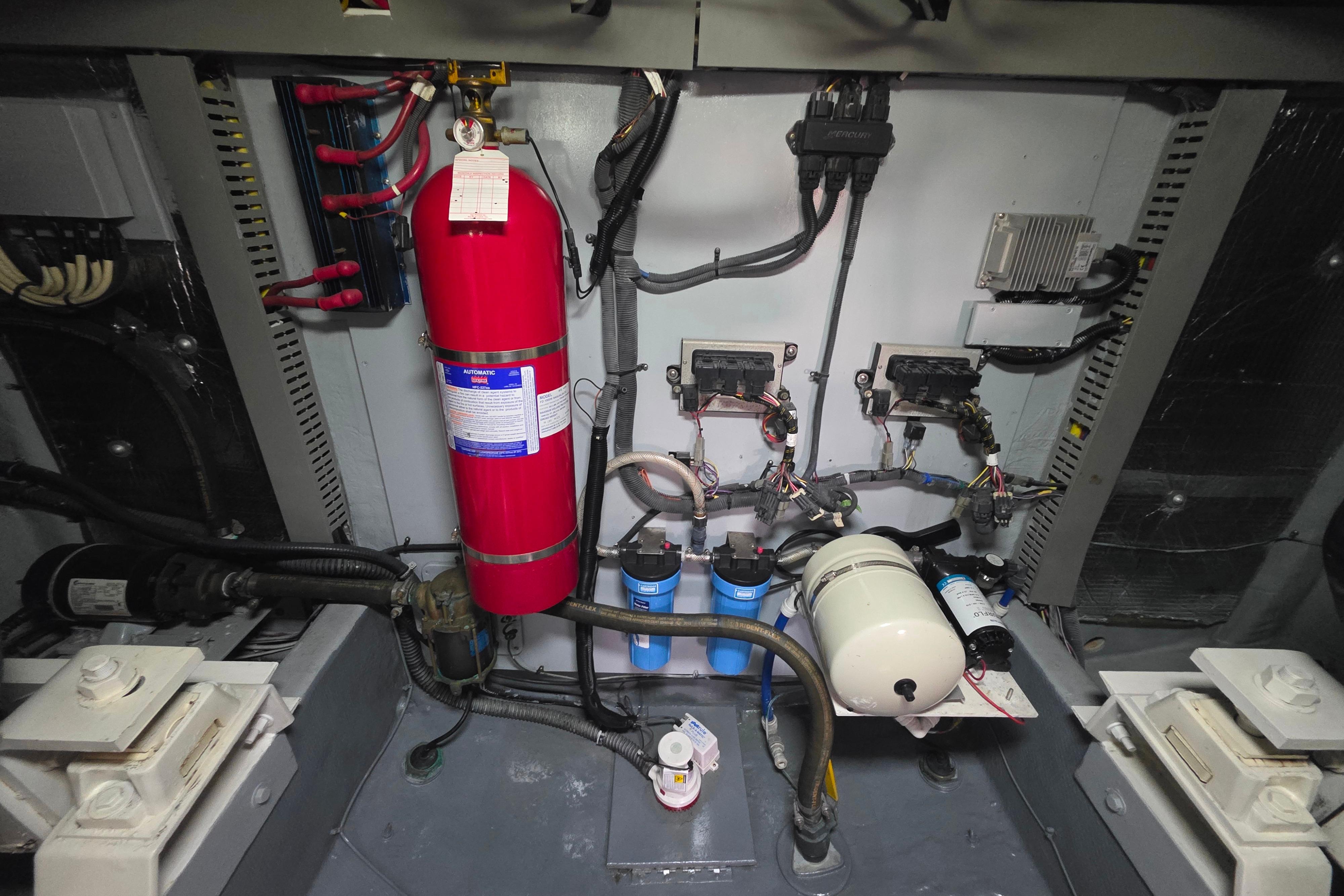 Engine room of 2005 Meridian 580 Pilothouse with fire extinguisher and mechanical components.