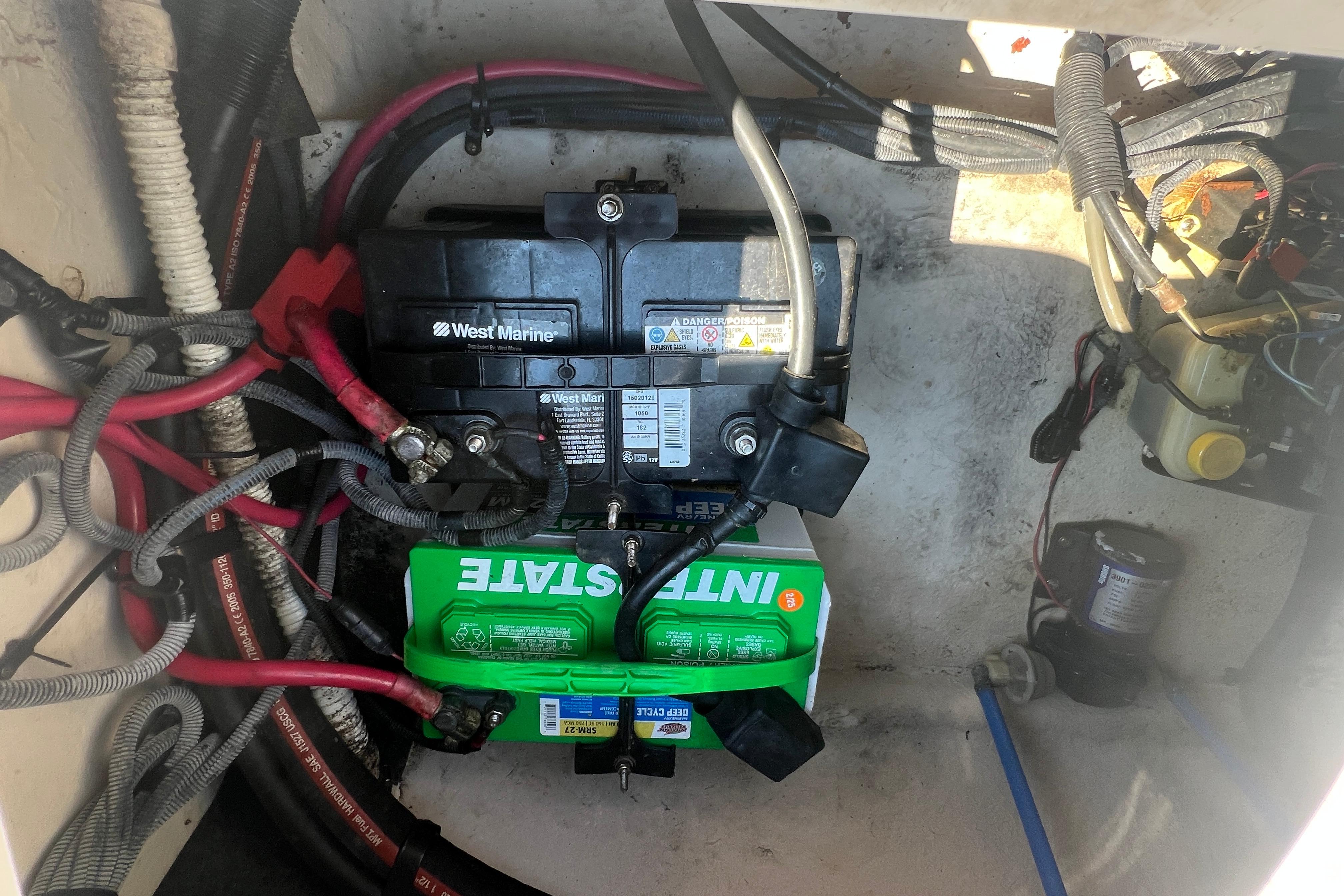 Battery compartment of a 2005 Sea Ray 240 Sundeck with West Marine and Interstate batteries.