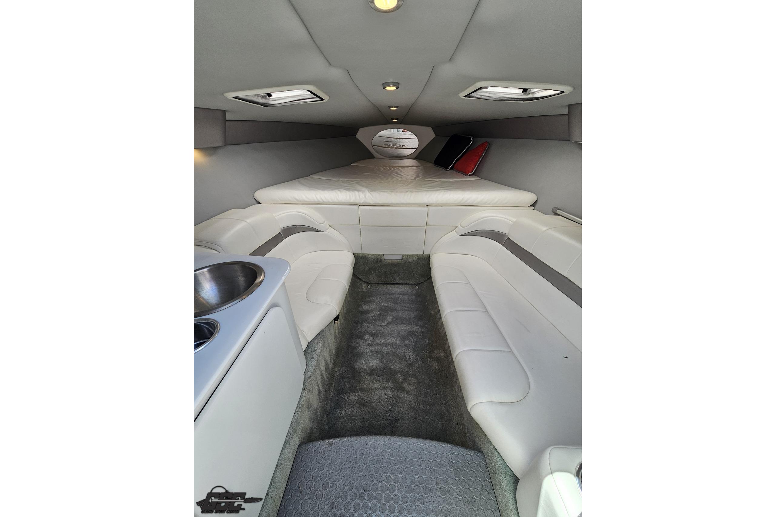 Interior of a 2005 Formula 271 FASTech boat, featuring white seating and a compact cabin.
