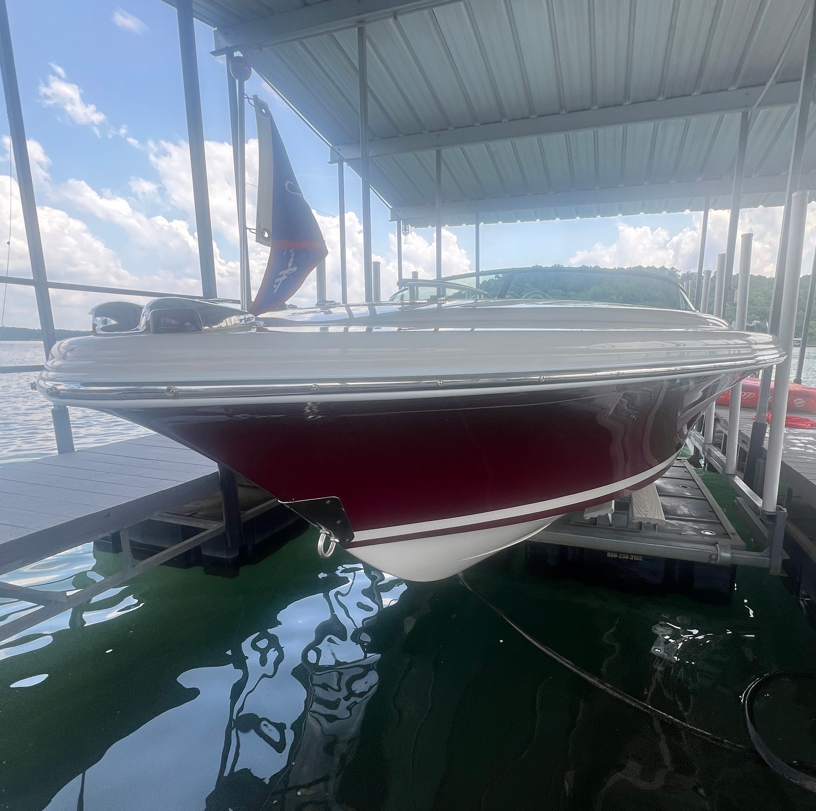A 2006 Chris-Craft Speedster 20 is docked in a covered boathouse on the water.