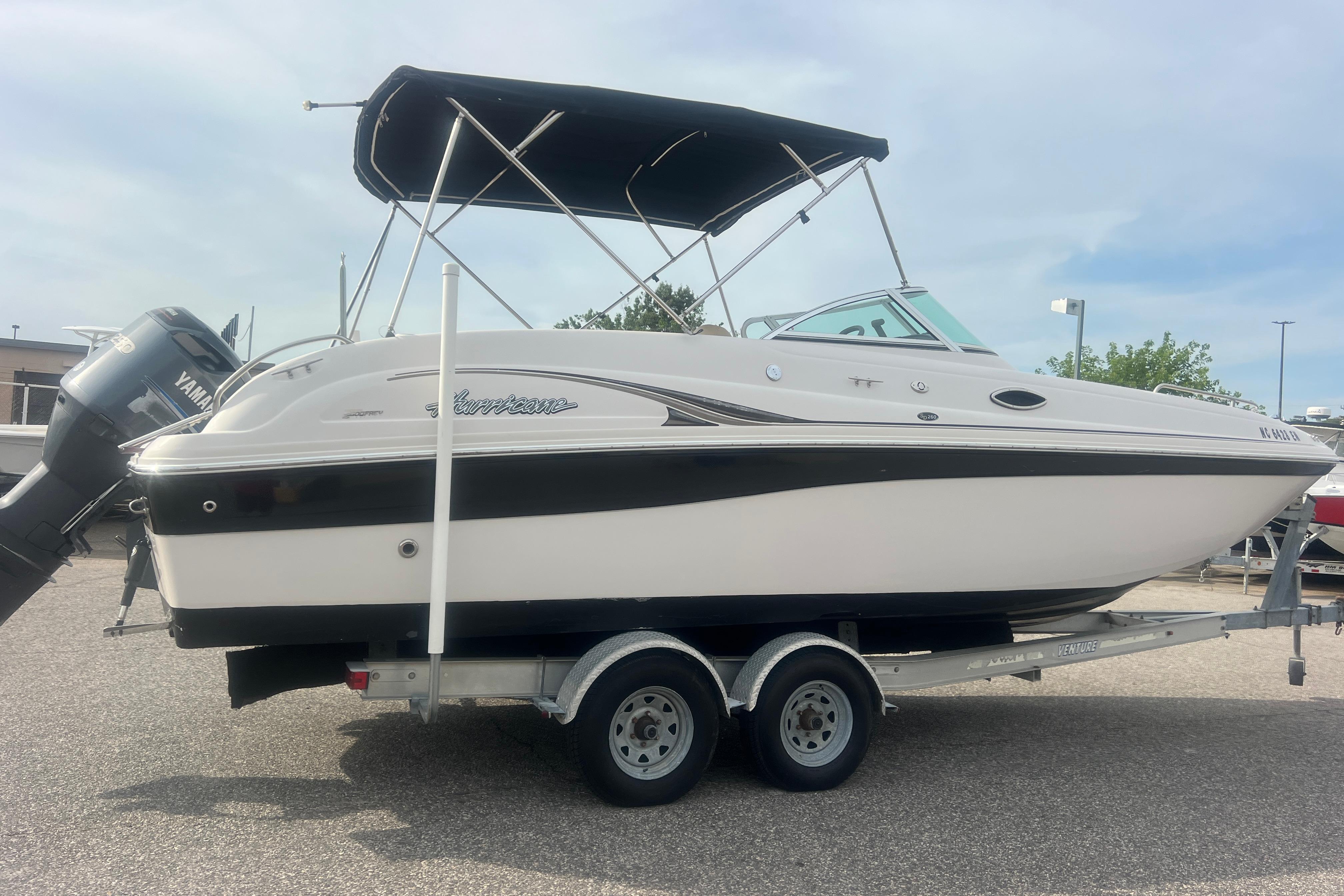 2002 Hurricane SunDeck 260 OB boat on trailer with Yamaha outboard motor.