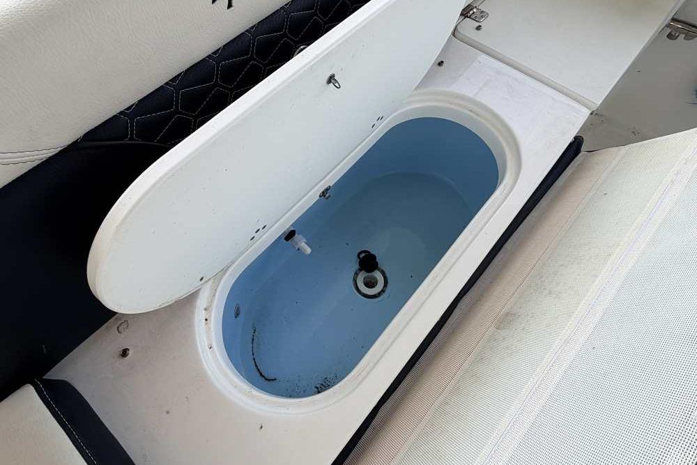 Livewell compartment on a 2024 Tidewater 232 LXF boat, featuring a sleek design.