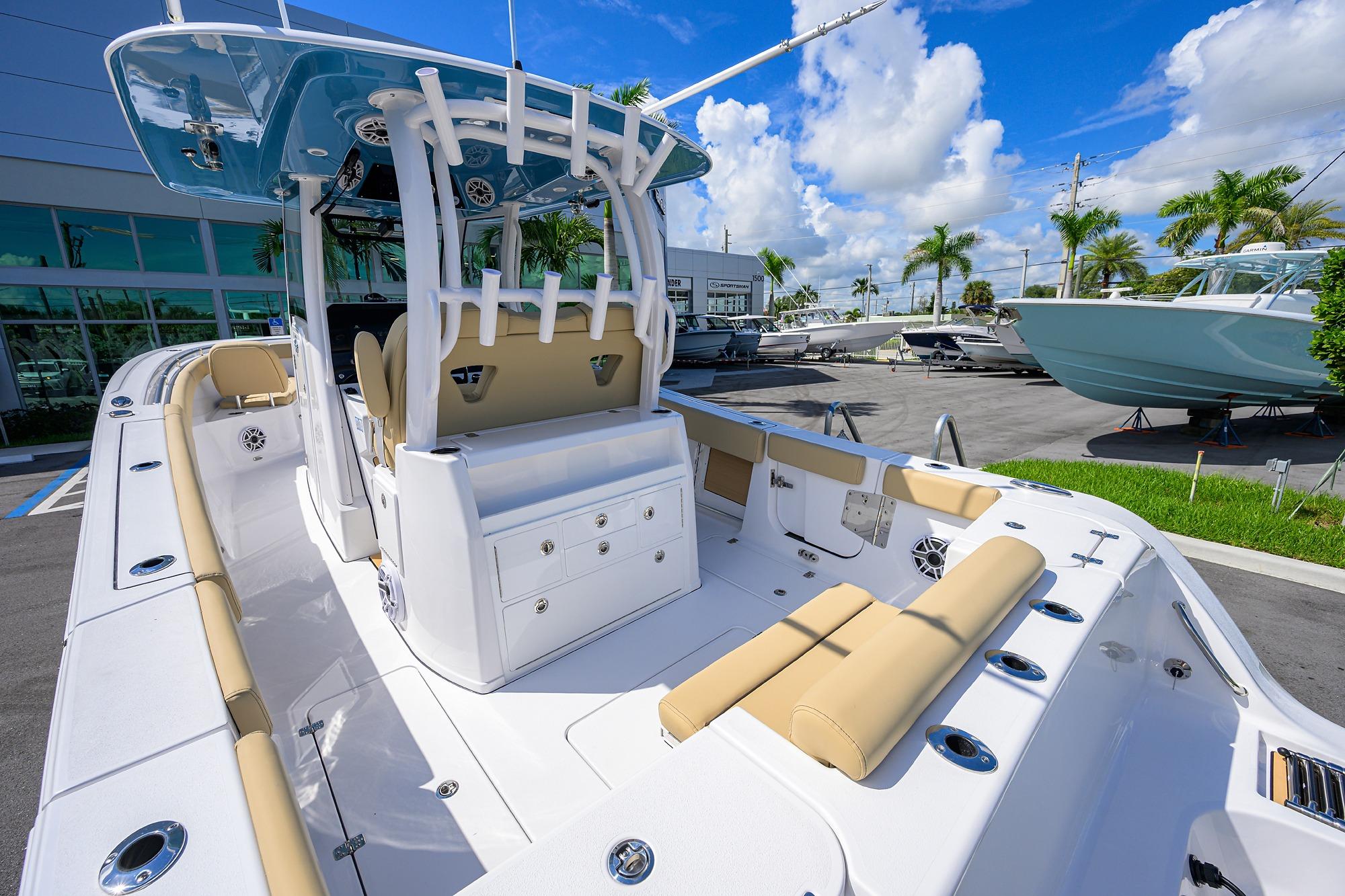 2026 Sportsman Open 302 Center Console boat with beige seating, docked under a blue sky.