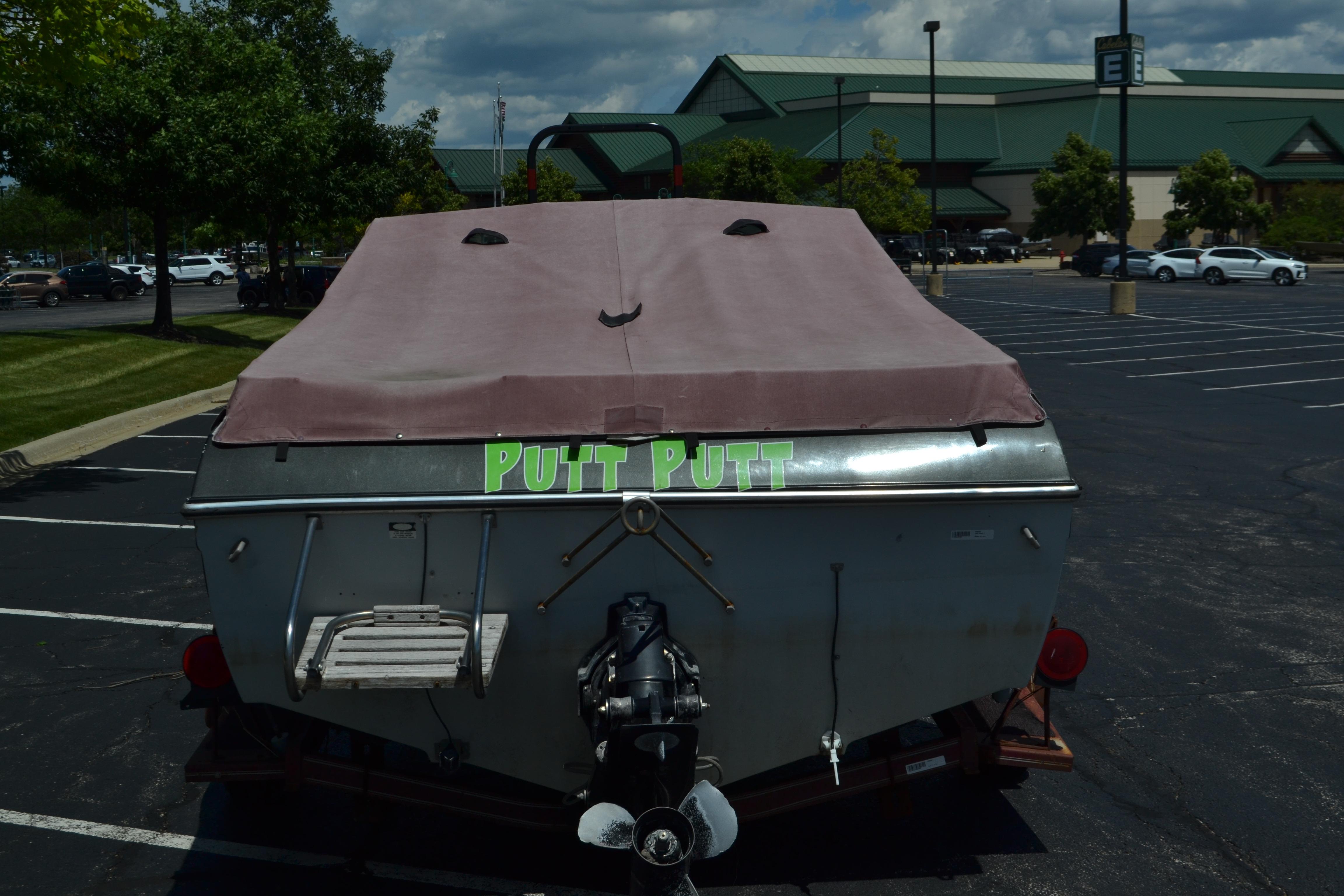 1985 Mach 1 MV 650 Eclipse boat with cover in parking lot, labeled "Putt Putt."