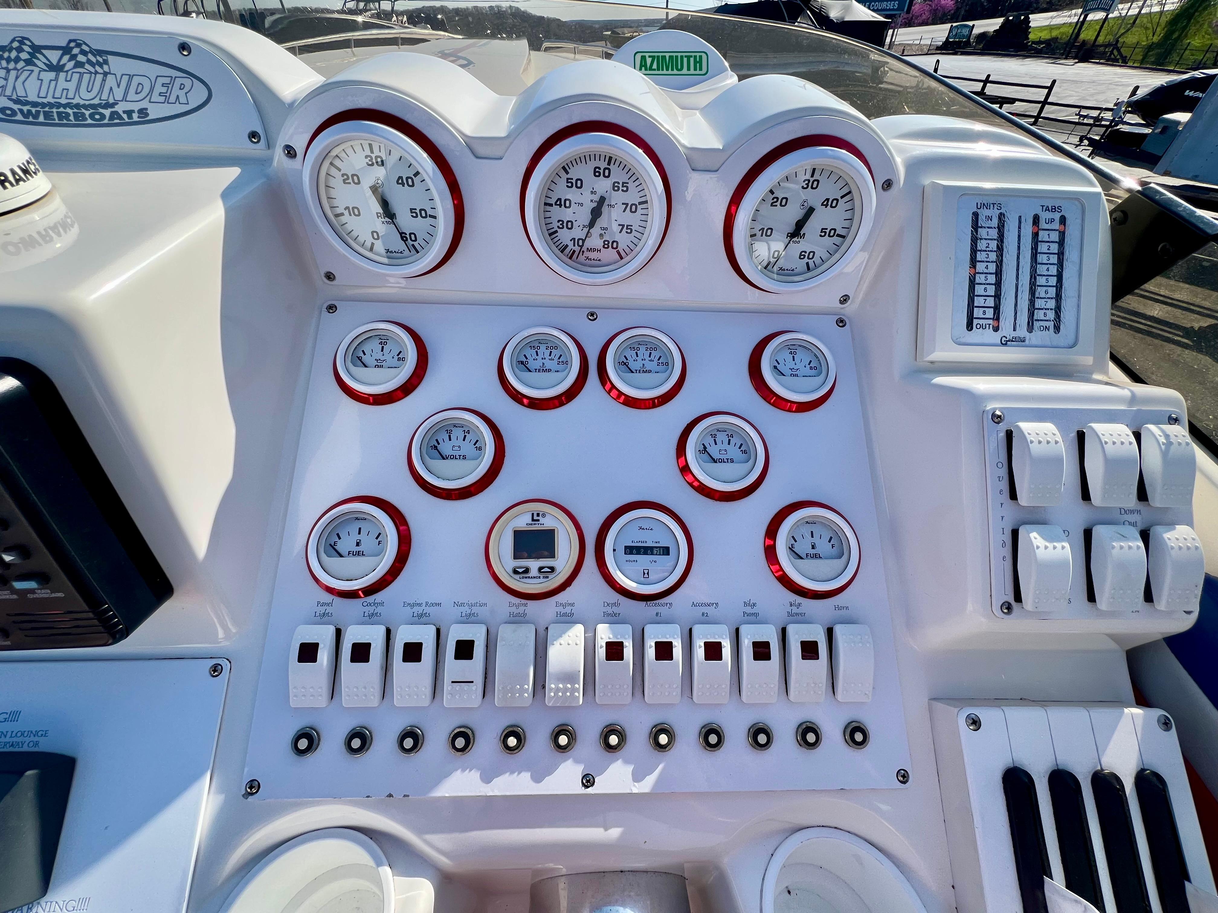 Dashboard of a 1999 Black Thunder 430 Flat Deck boat with gauges and controls.