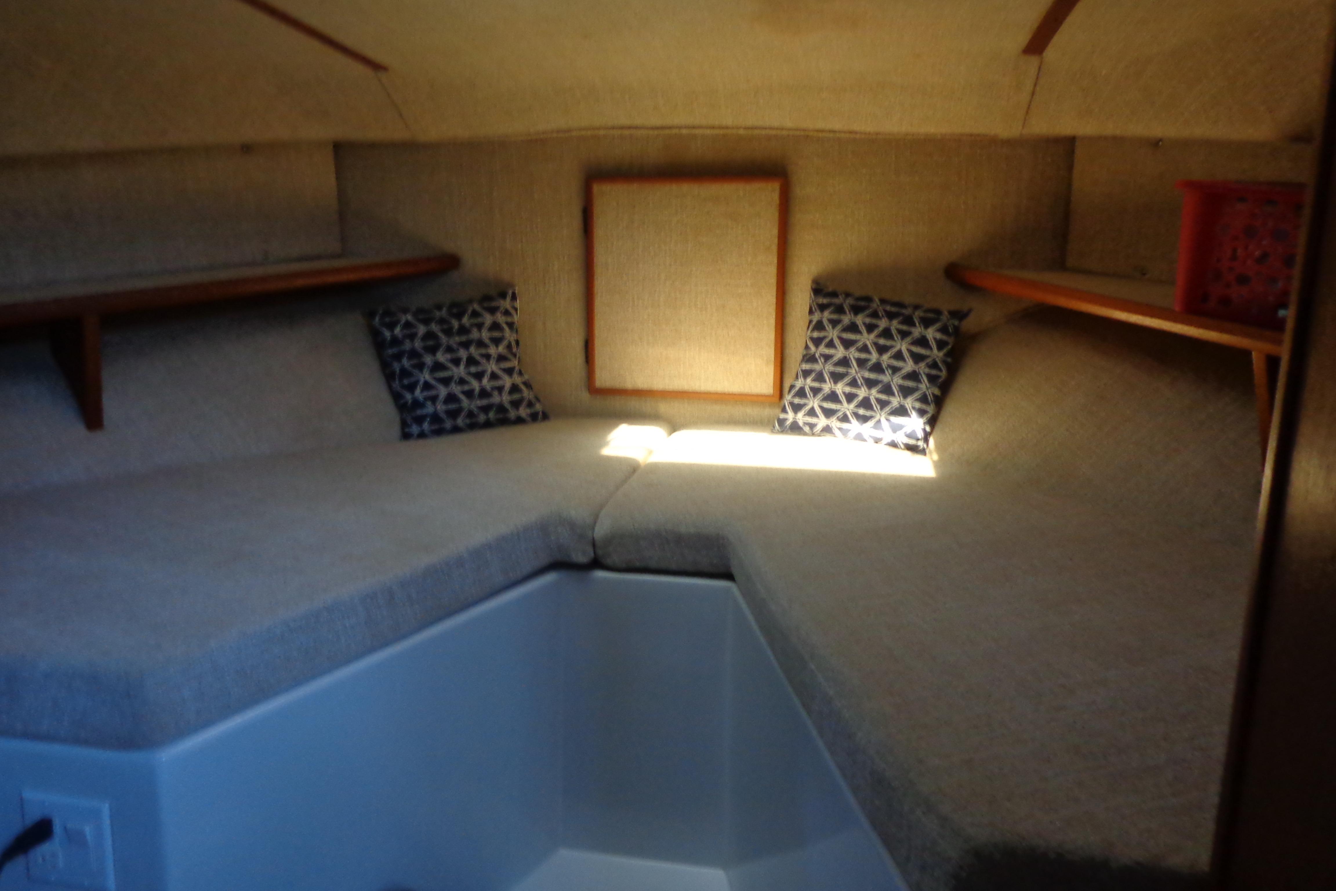 Interior cabin of 1992 Cruise-A-Home Corsair 4200 with cozy seating and decorative pillows.