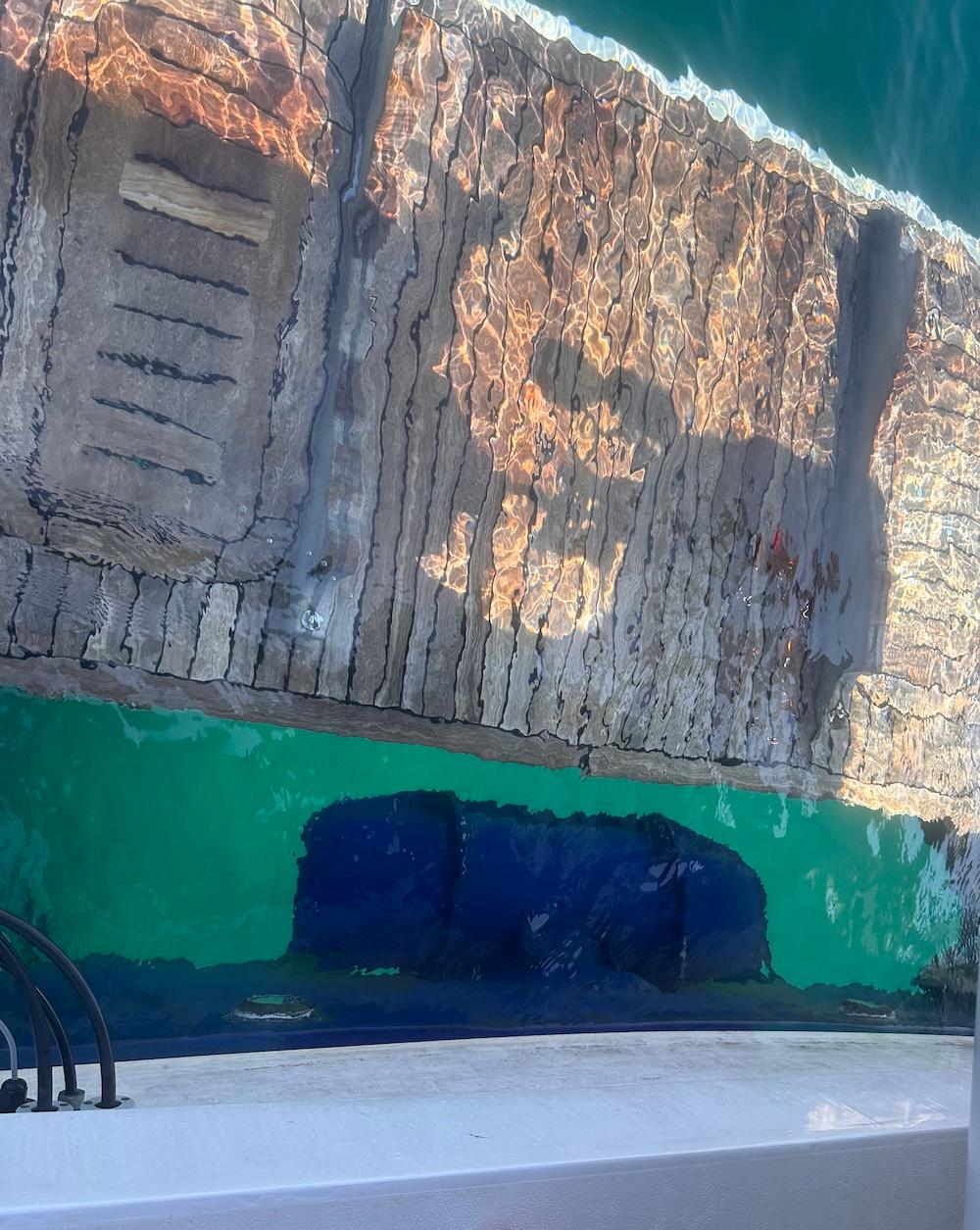 Reflection of a dock and water beside a 2009 Princess V62 yacht.