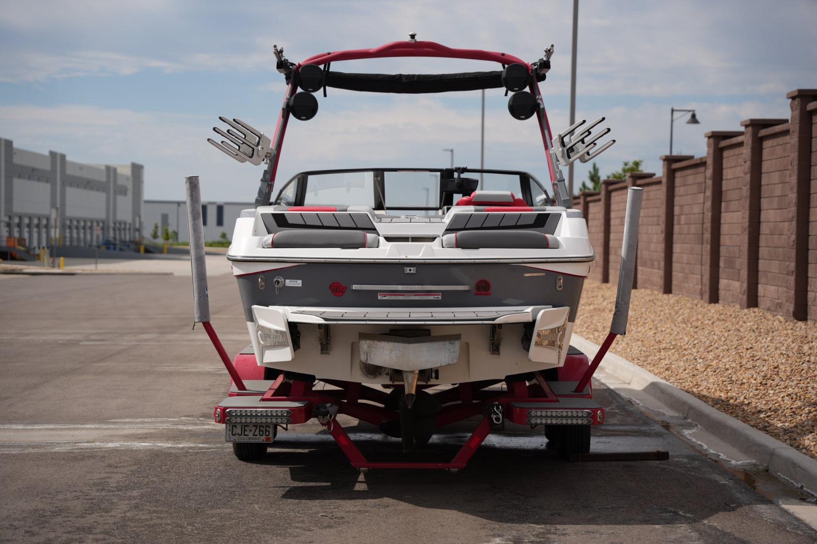 2022 Malibu Wakesetter 23 MXZ boat on trailer, parked in urban area.