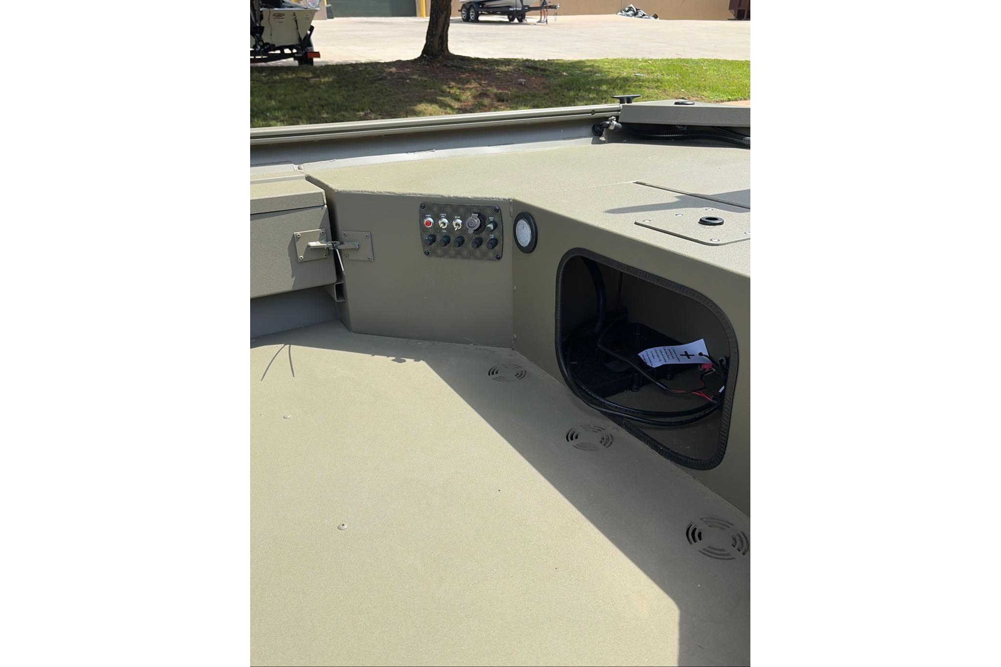 2026 Tracker Grizzly 1654 T Sportsman boat interior with control panel and storage compartment.