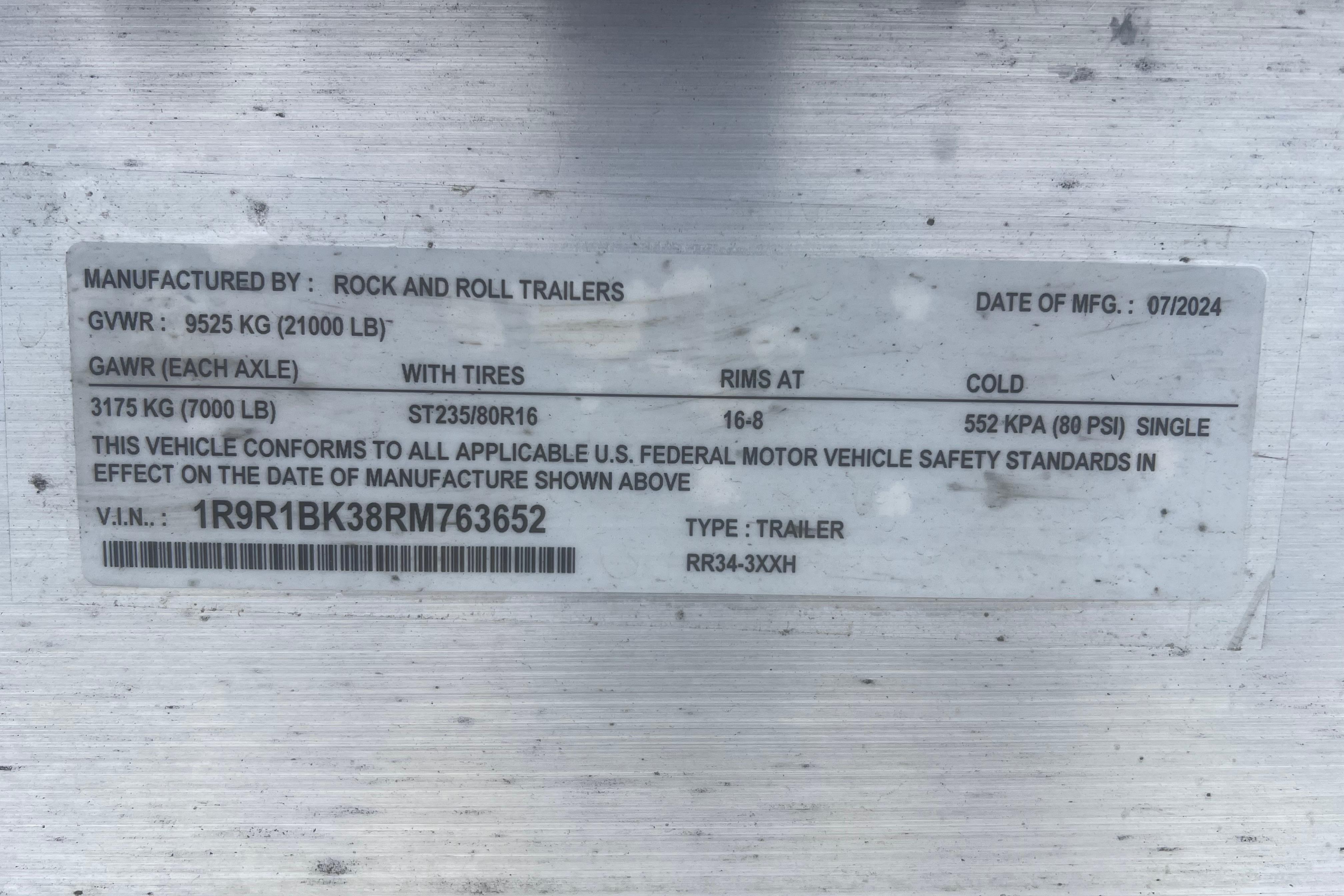 Label on a trailer showing specifications and compliance details, manufactured by Rock and Roll Trailers.