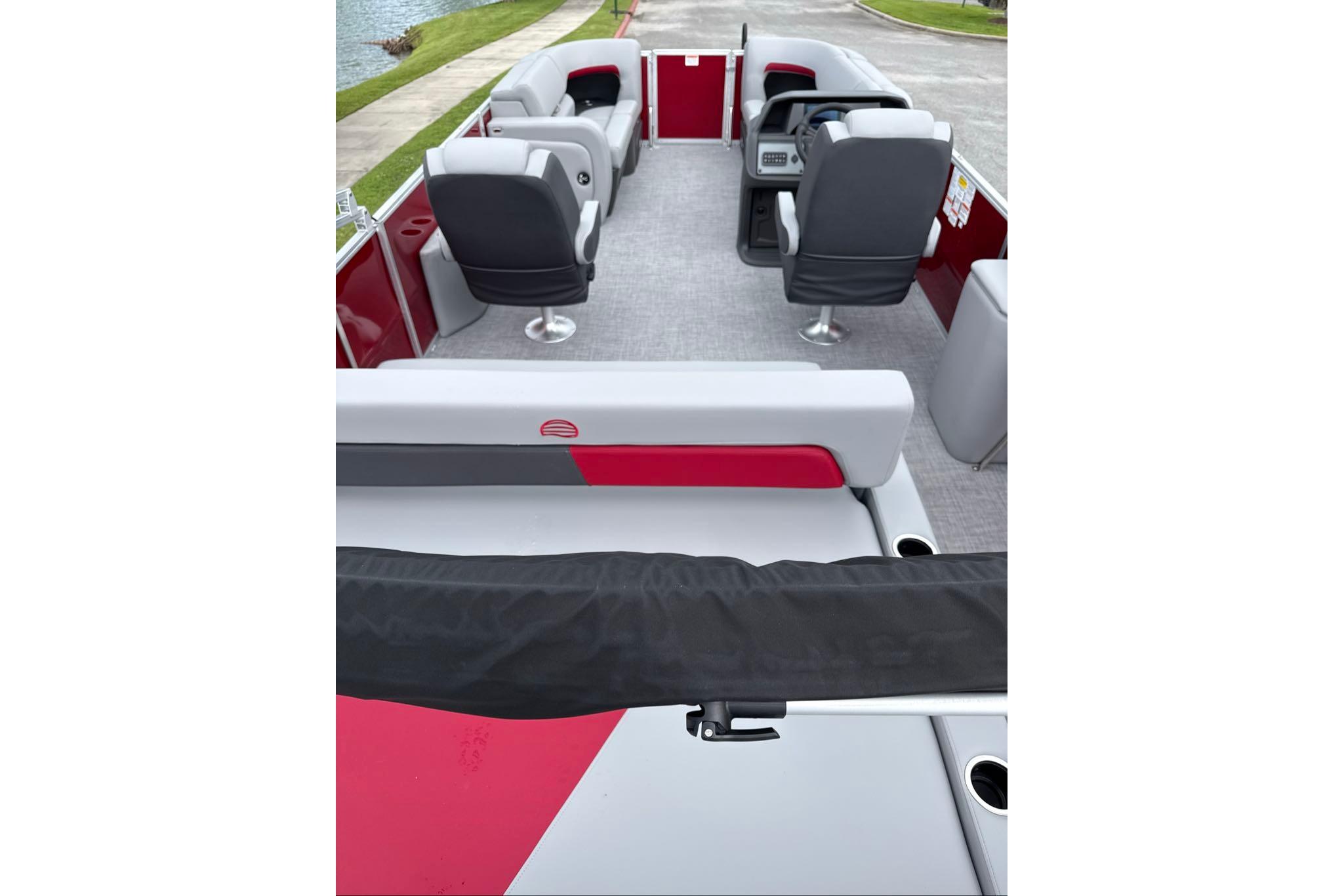 2026 Sun Tracker Party Barge 22 RF DLX interior with seating and helm, dockside view.
