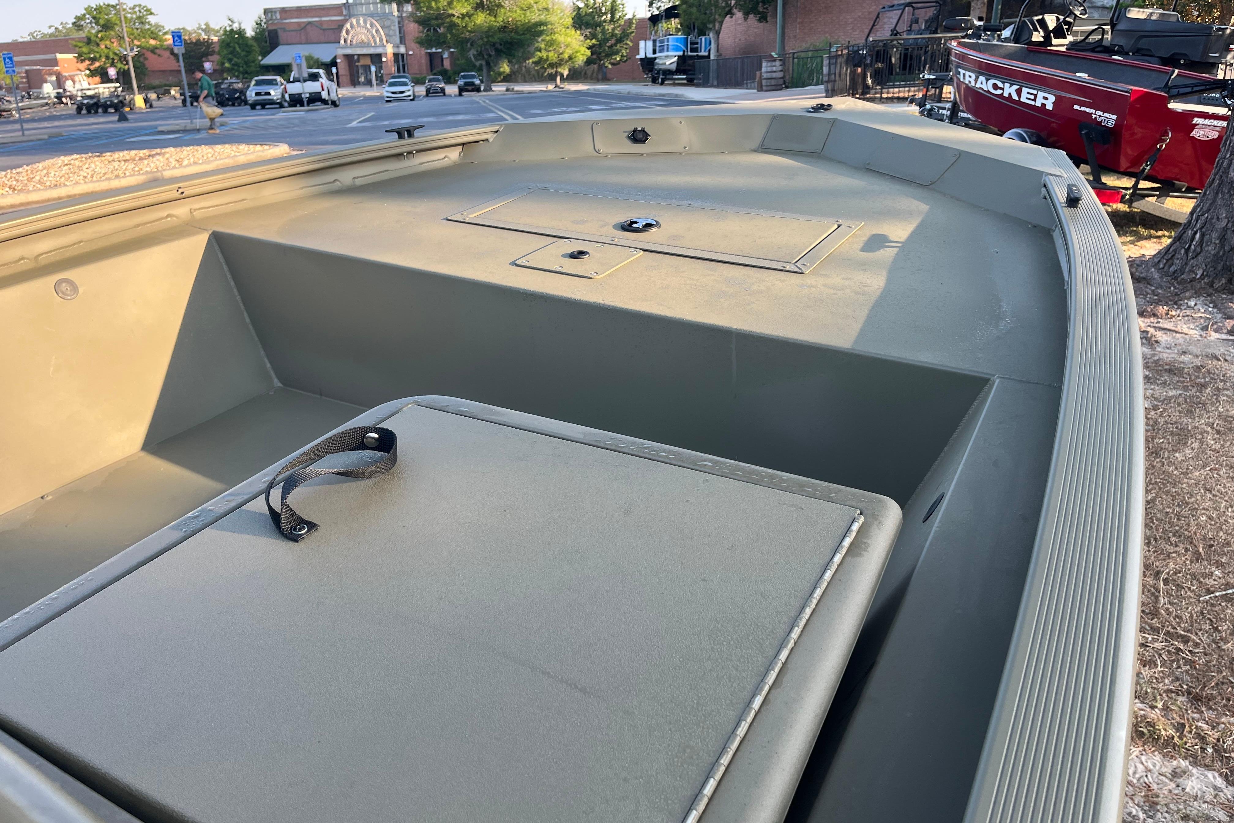 2026 Tracker Grizzly 1648 SC boat interior with storage compartments, parked outdoors.