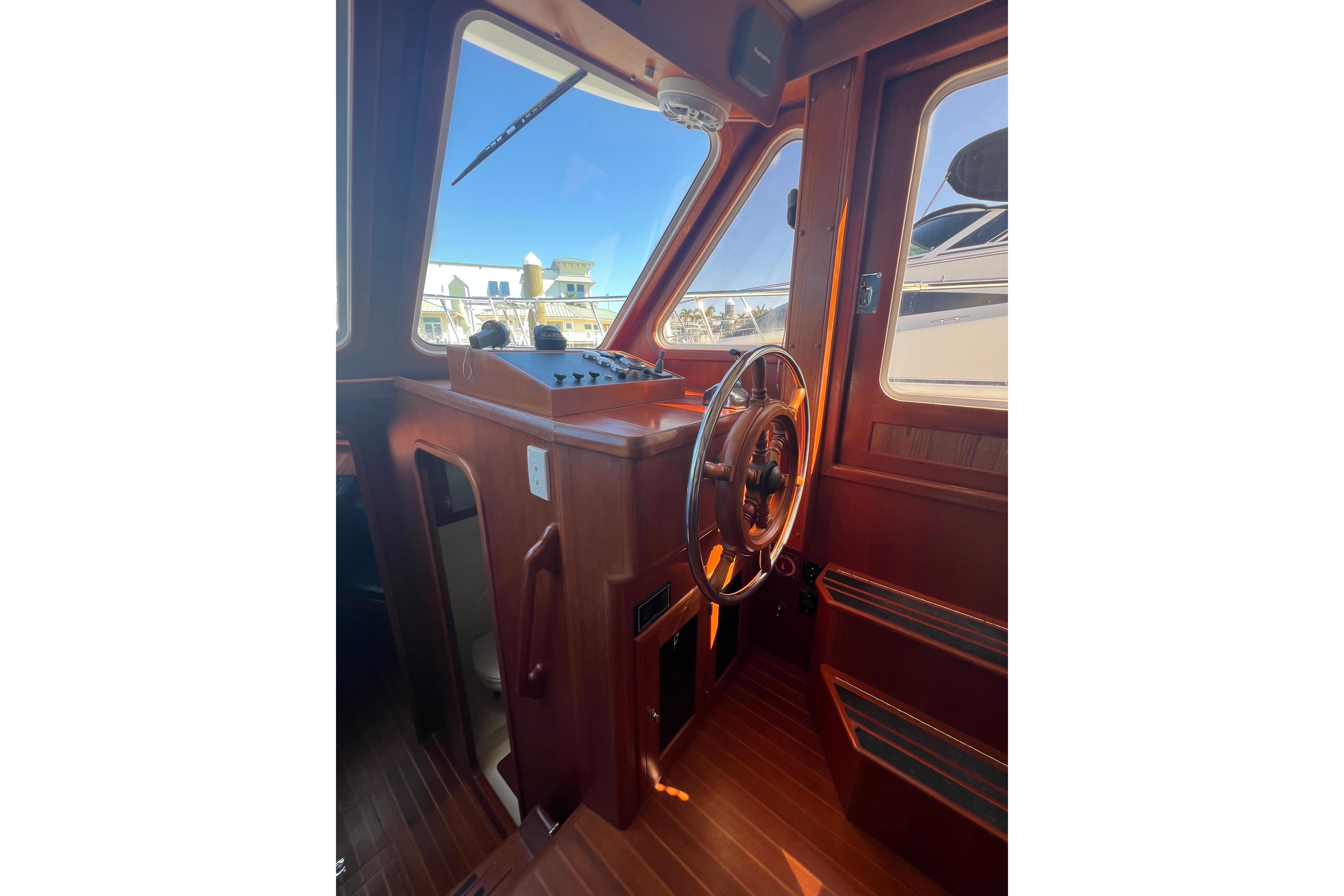 2007 Heritage East 36 Sundeck Trawler helm with wooden steering wheel and control panel.