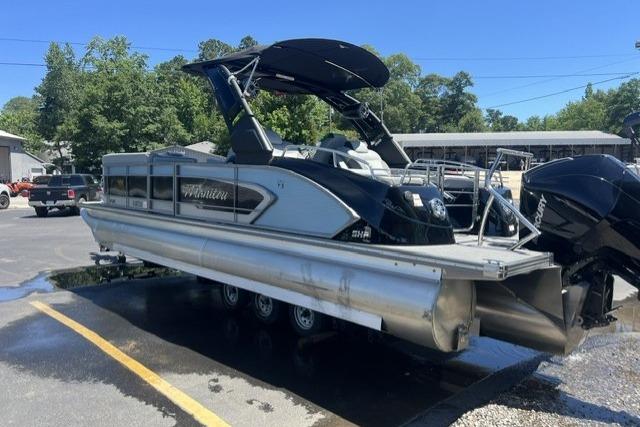 2024 Manitou 25 LX SRW pontoon boat with sleek design, parked outdoors.
