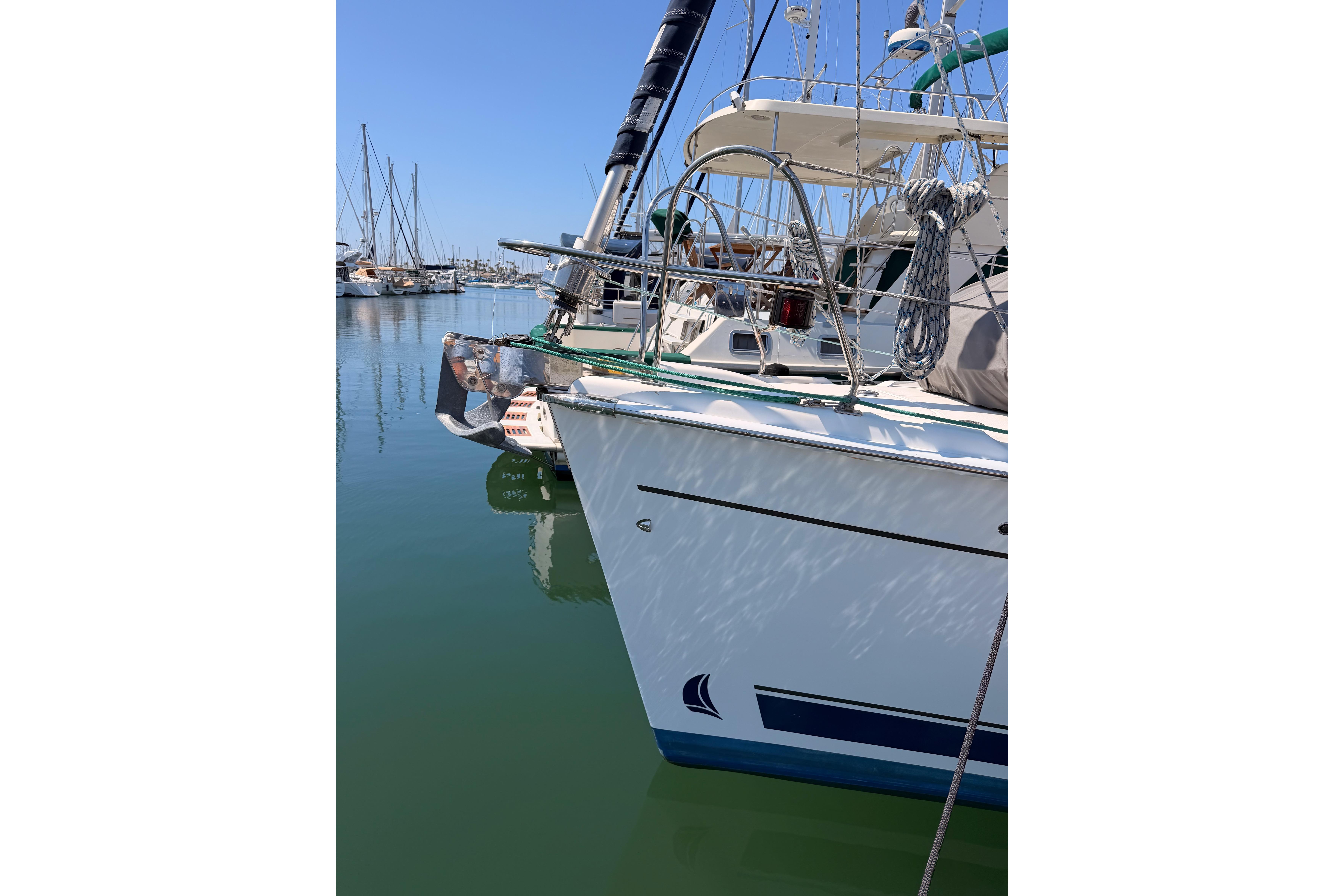 2008 Hunter 45 Deck Salon yacht docked in a marina, reflecting on calm water.