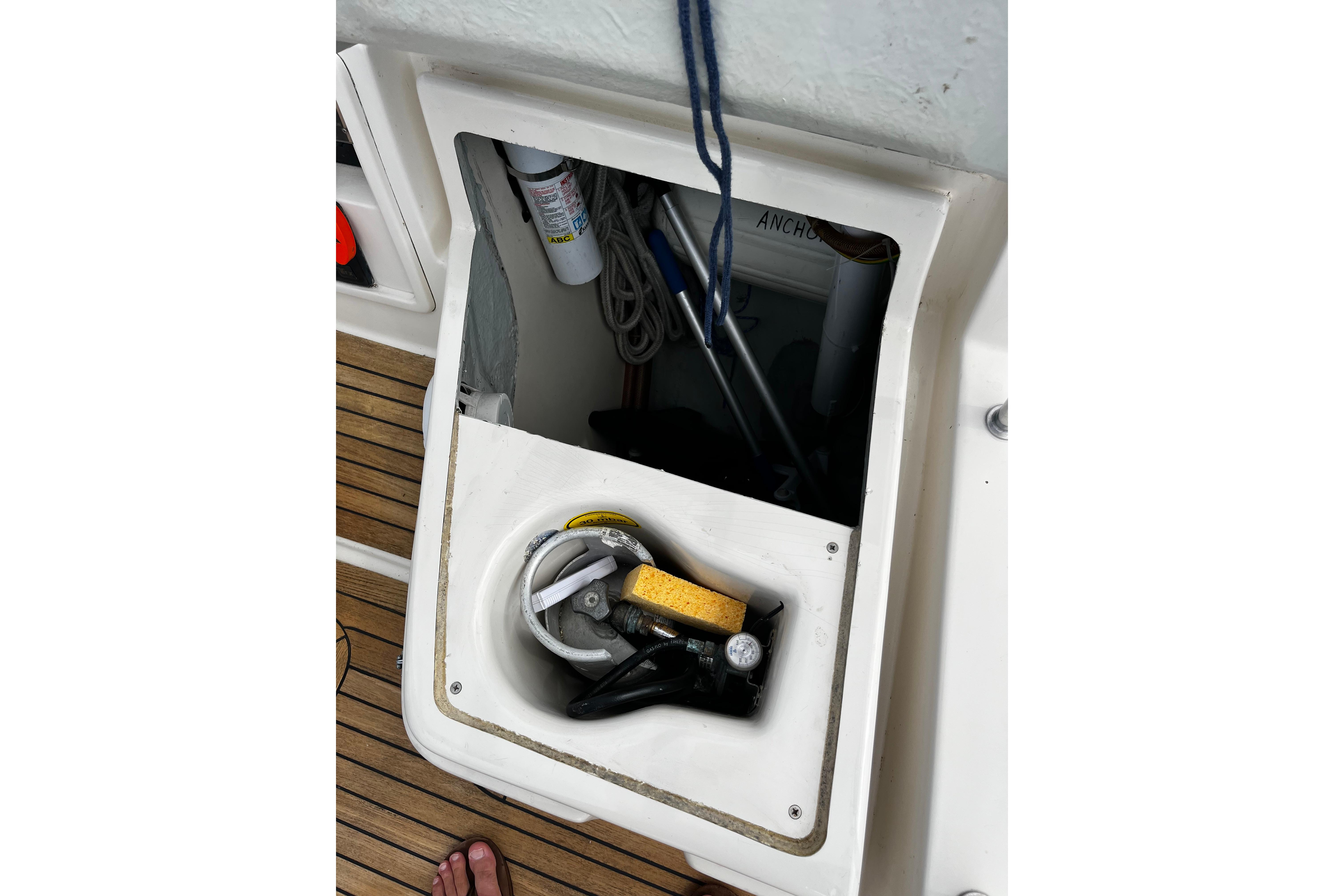 Open storage compartment on 2004 Hanse 411 sailboat deck with nautical equipment.
