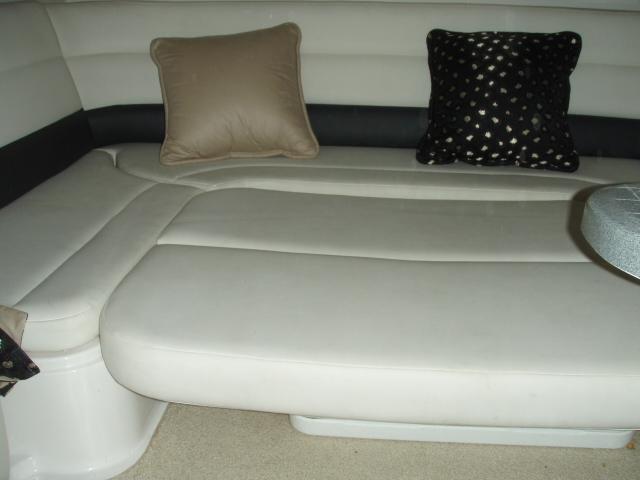 2003 Wellcraft 3300 Martinique interior with beige seating and decorative pillows.