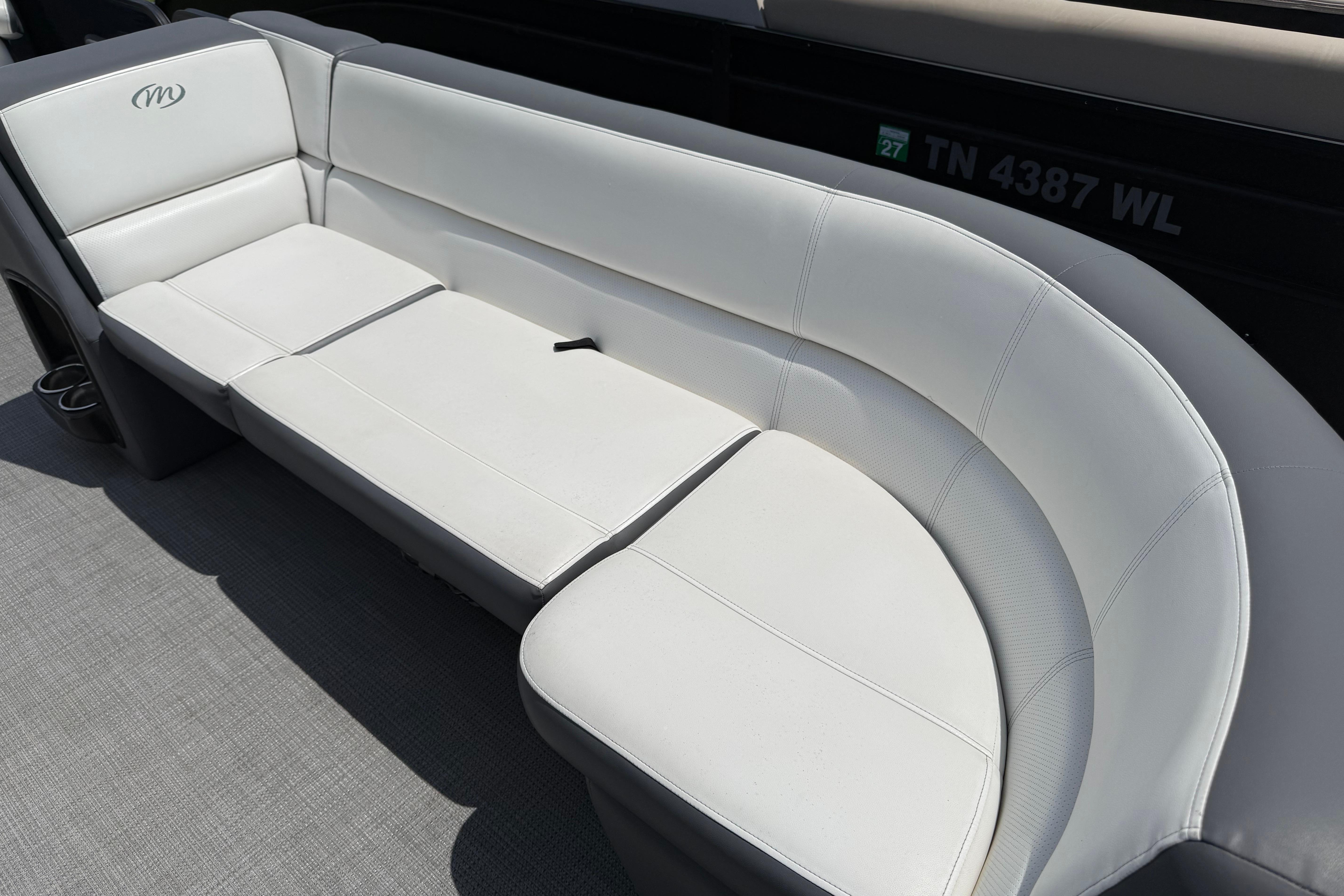 2022 Manitou Aurora LE boat interior with white cushioned seating.