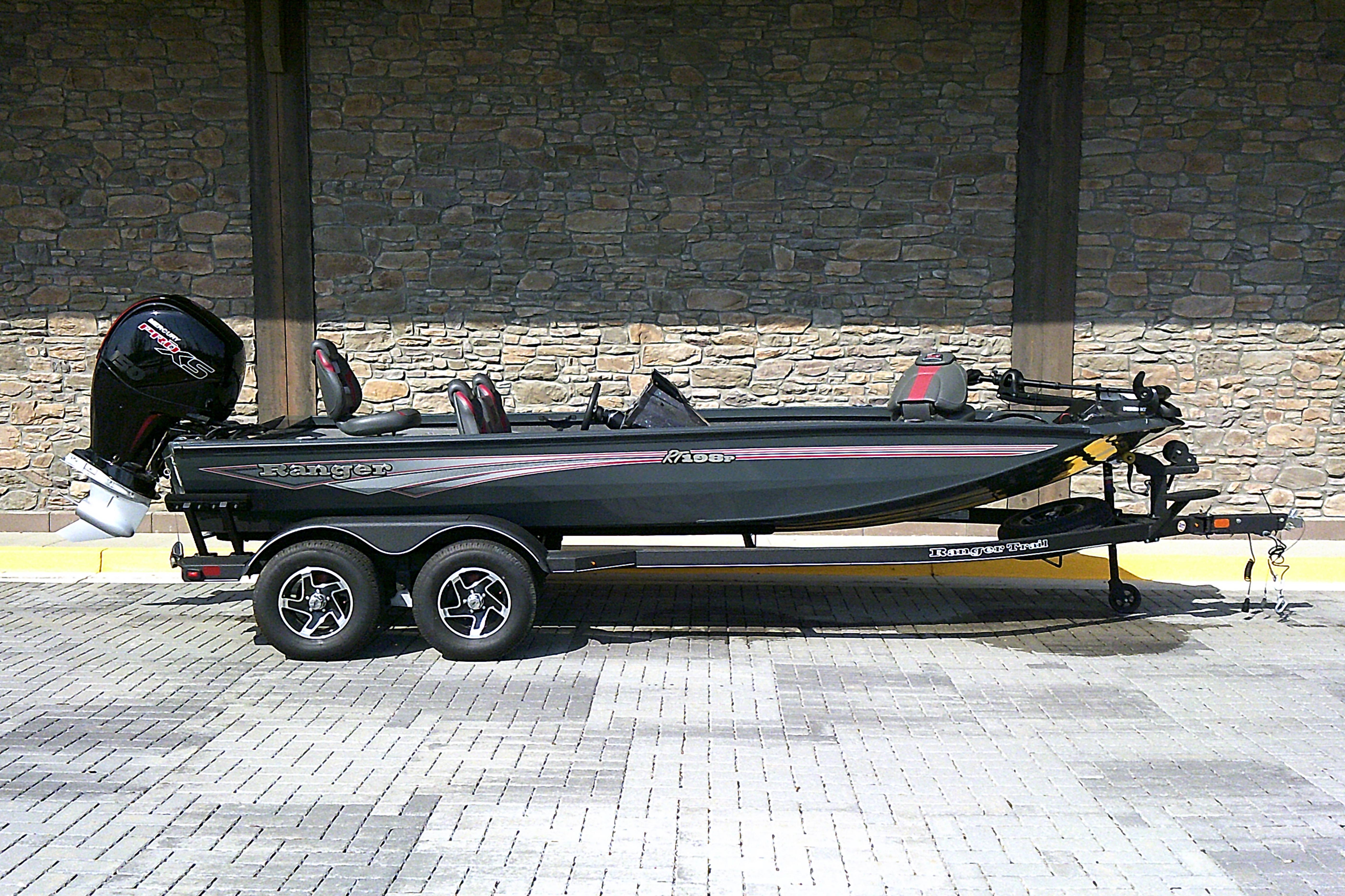 2025 Ranger RT198P boat on trailer, parked against stone wall background.