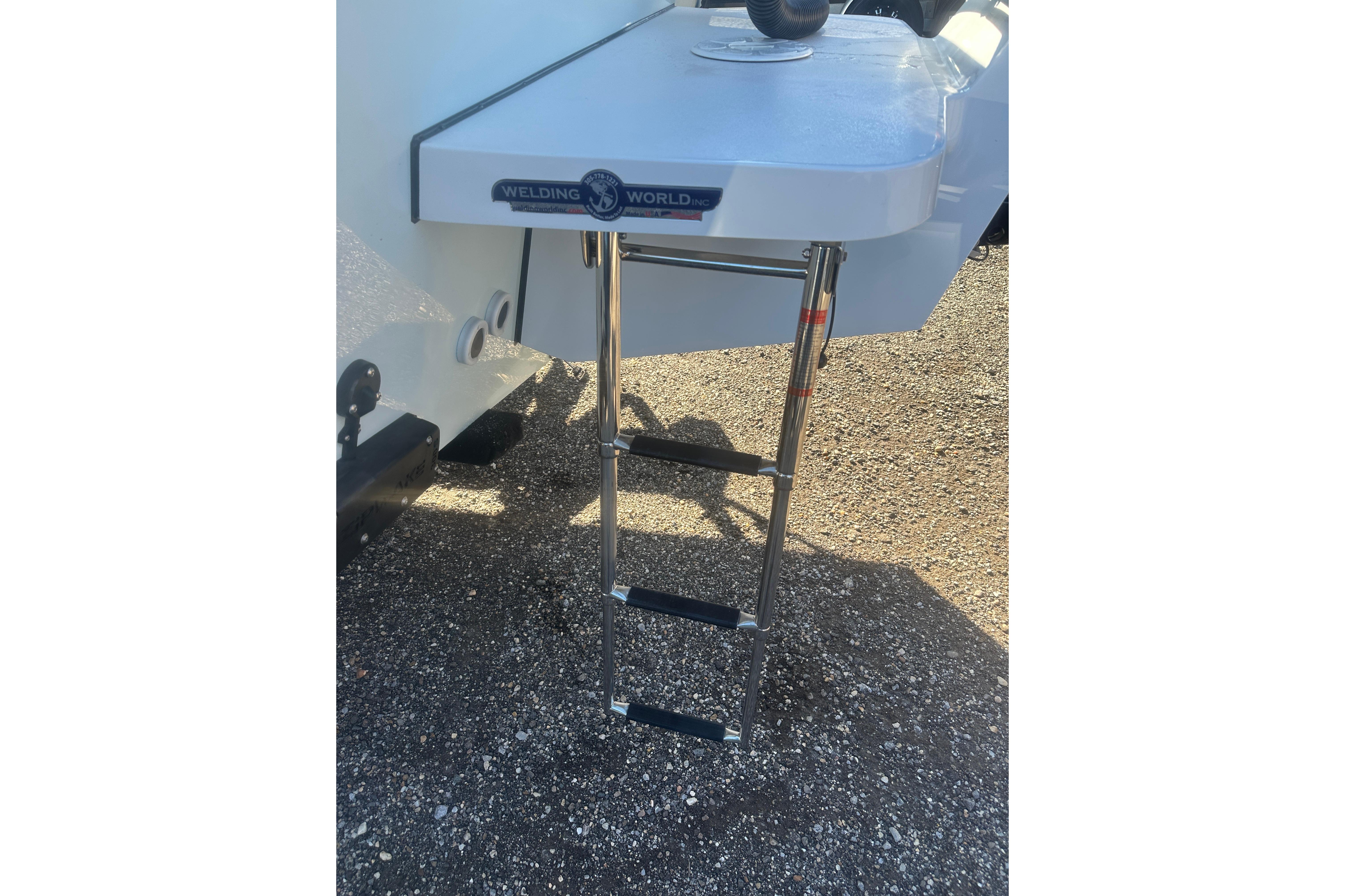 2026 Delta D245 boat with a stainless steel ladder on a sunny day.