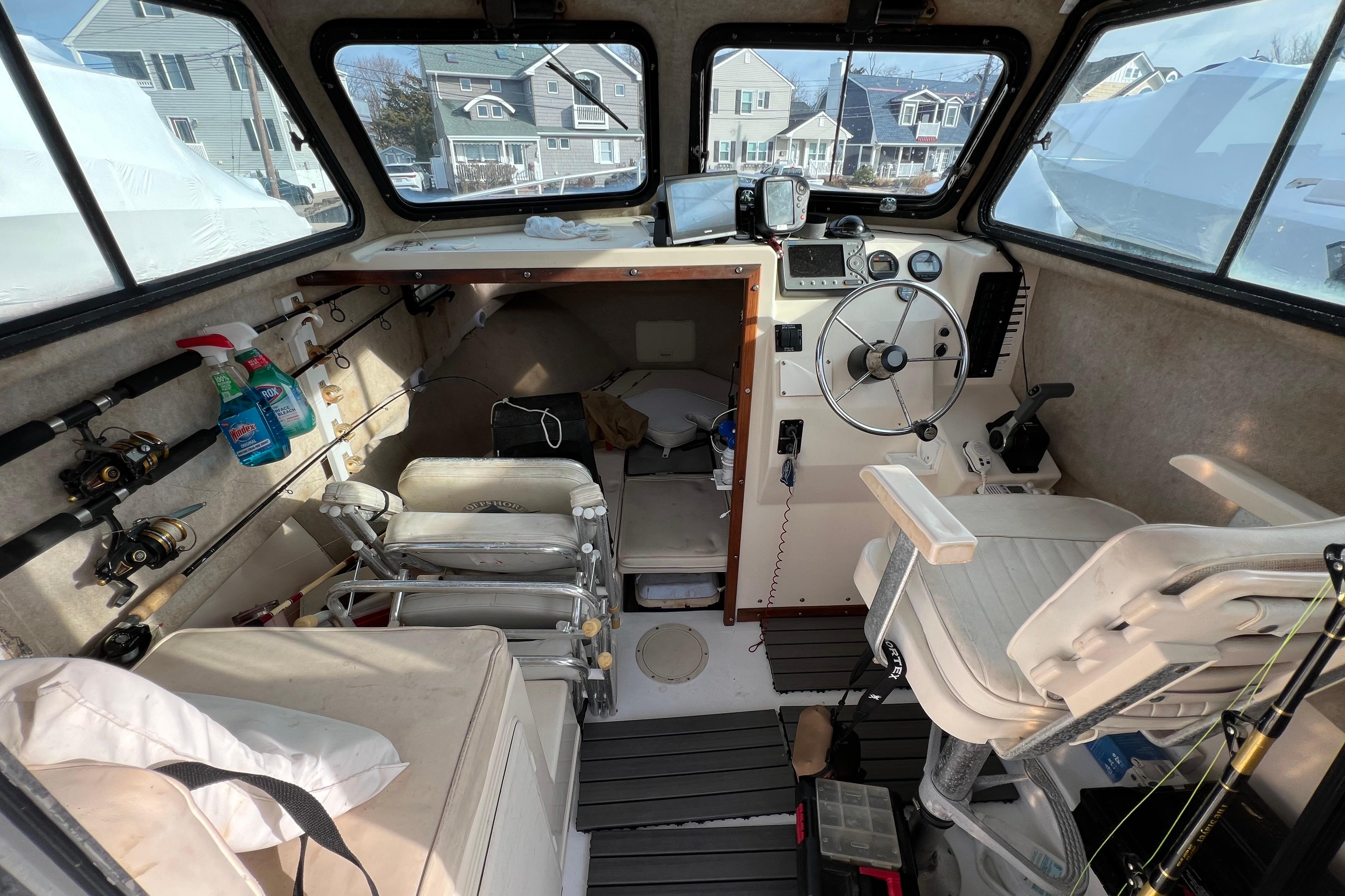 Interior of a 2001 Parker 2520 Deep Vee Sport Cabin boat with fishing gear.
