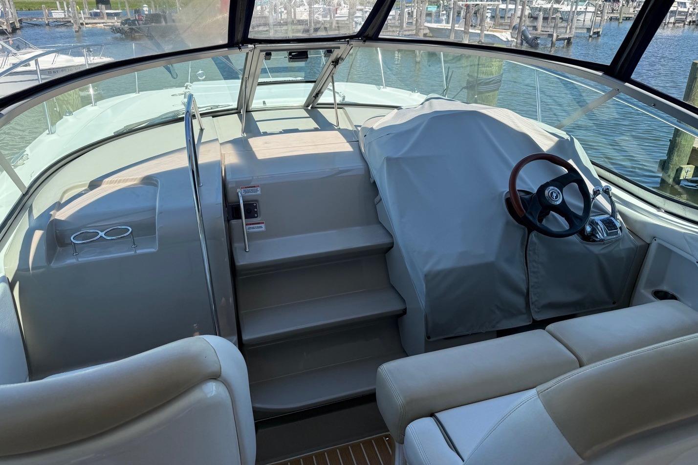 2008 Sea Ray Sundancer 330 cockpit with covered helm, steering wheel, and marina view.
