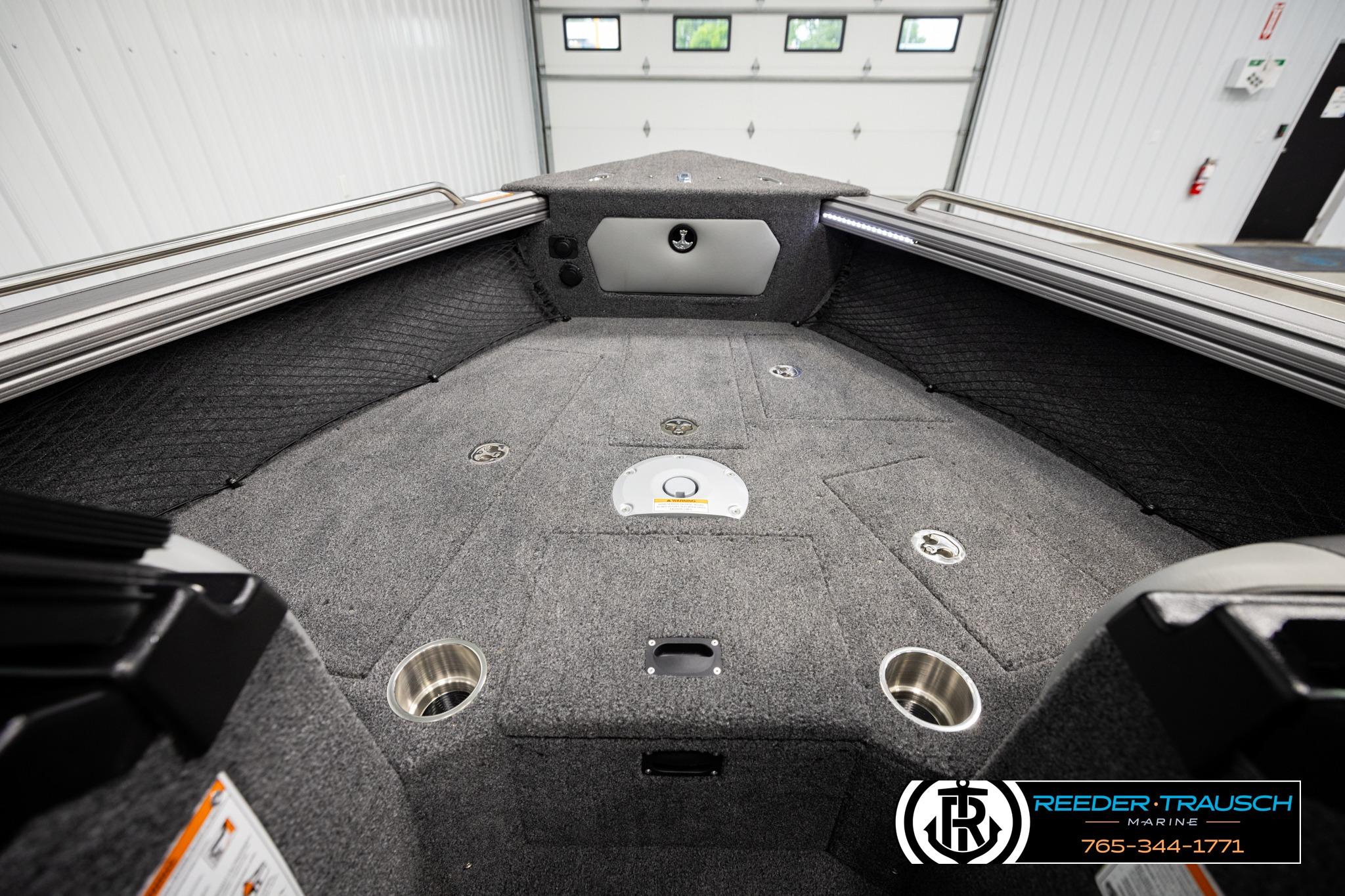 Interior of 2026 Lund 1975 Tyee boat with carpeted deck and storage compartments.